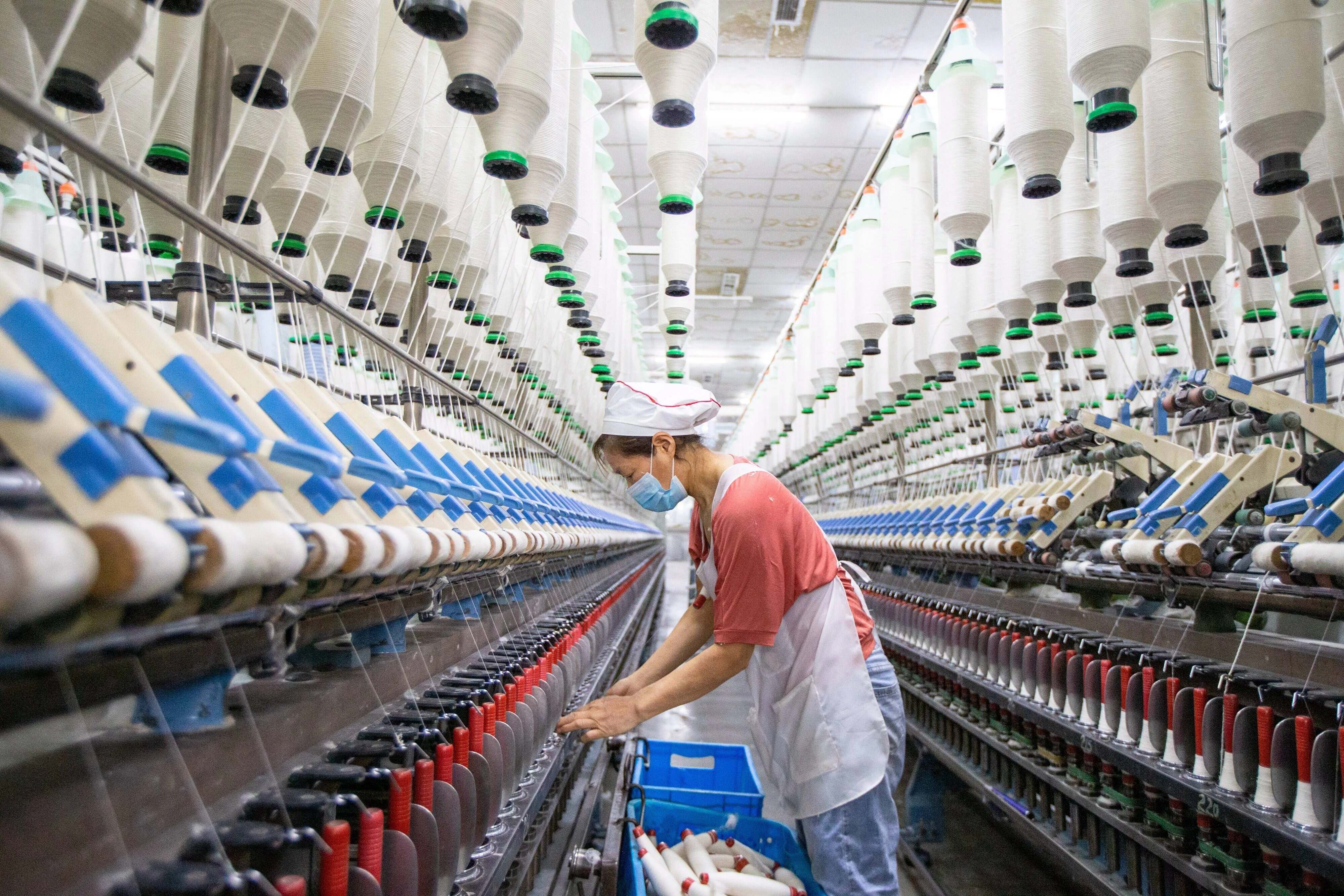 Eine Arbeiterin arbeitet an einer Webmaschine eines Textilunternehmens in der Gemeinde Nanmo der Stadt Hai in der ostchinesischen Provinz Jiangsu.