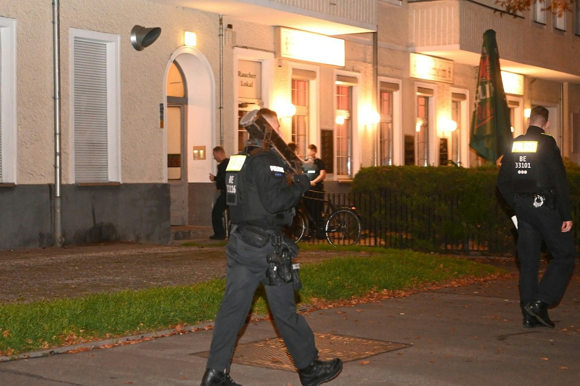 Ein Polizist trägt eine Ramme zum Einsatzort.