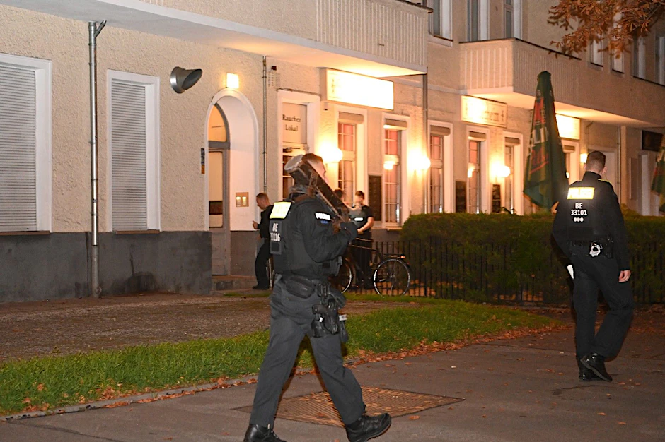 Ein Polizist trägt eine Ramme zum Einsatzort.