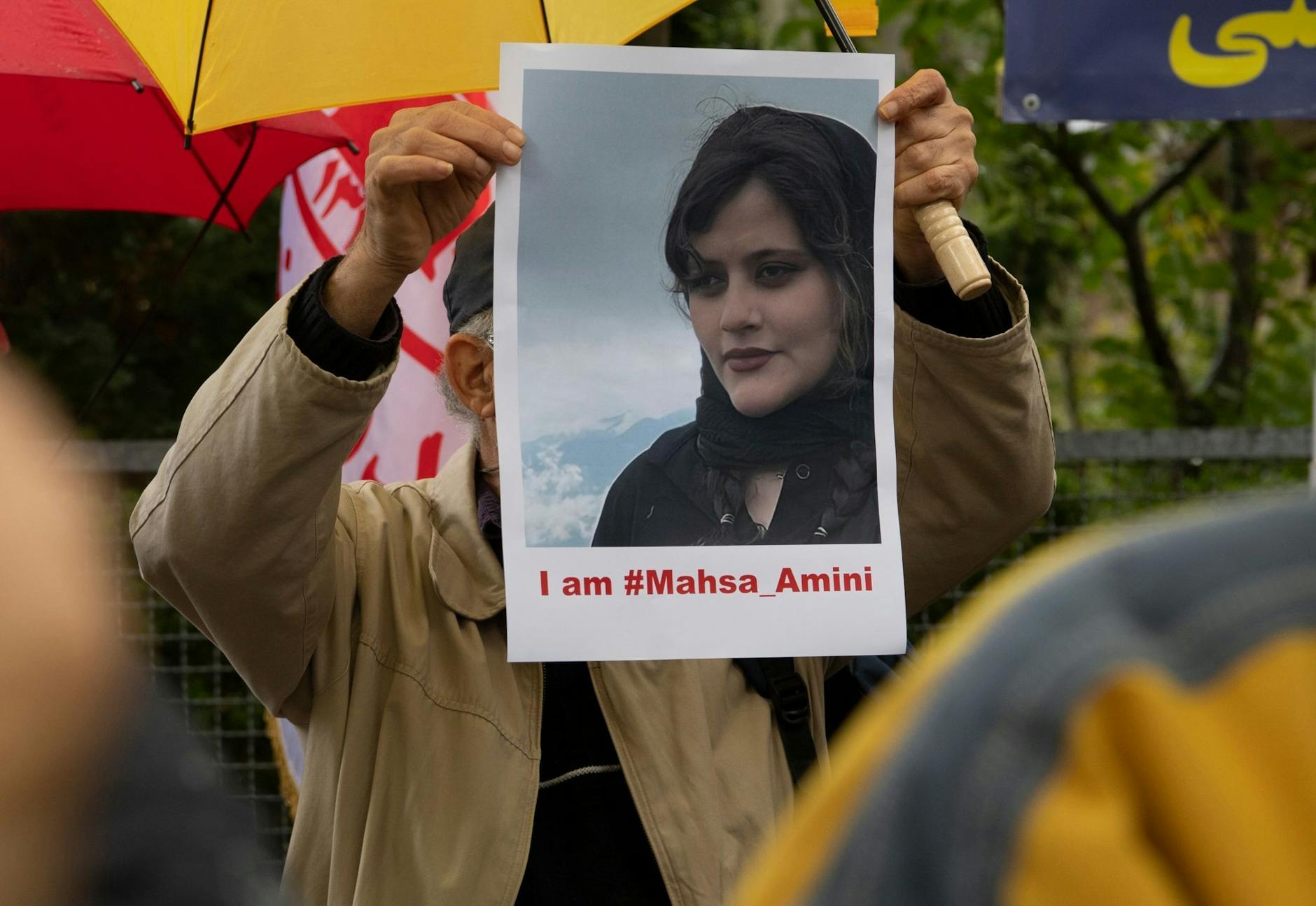 Bei einem Protest in Berlin hält ein Mann ein Bild der verstorbenen Mahsa Amini in Händen. - Nutzung nur nach schriftlicher Vereinbarung mit der dpa