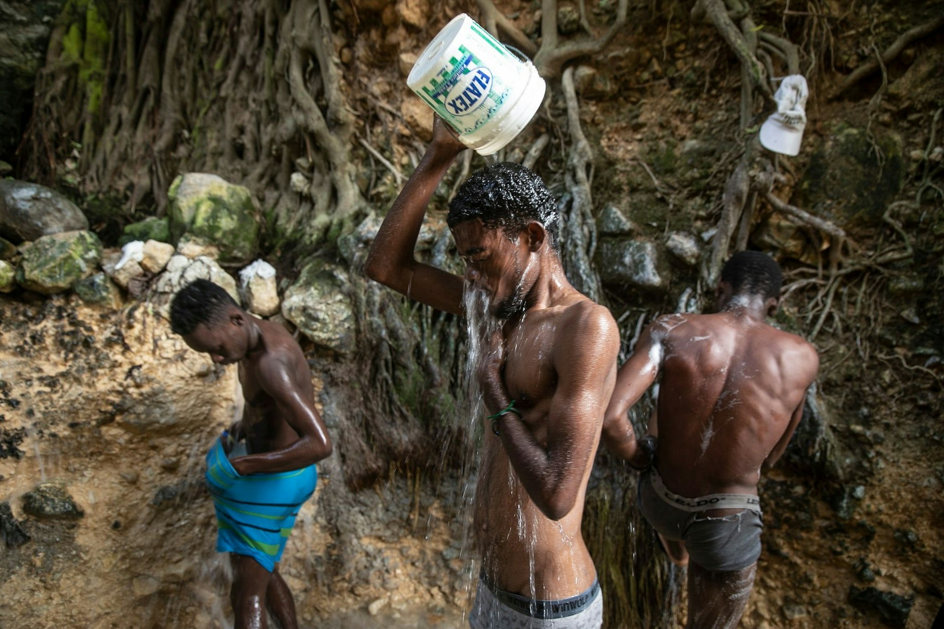 Menschen waschen sich in einer Schlucht in Port-Au-Prince.  
