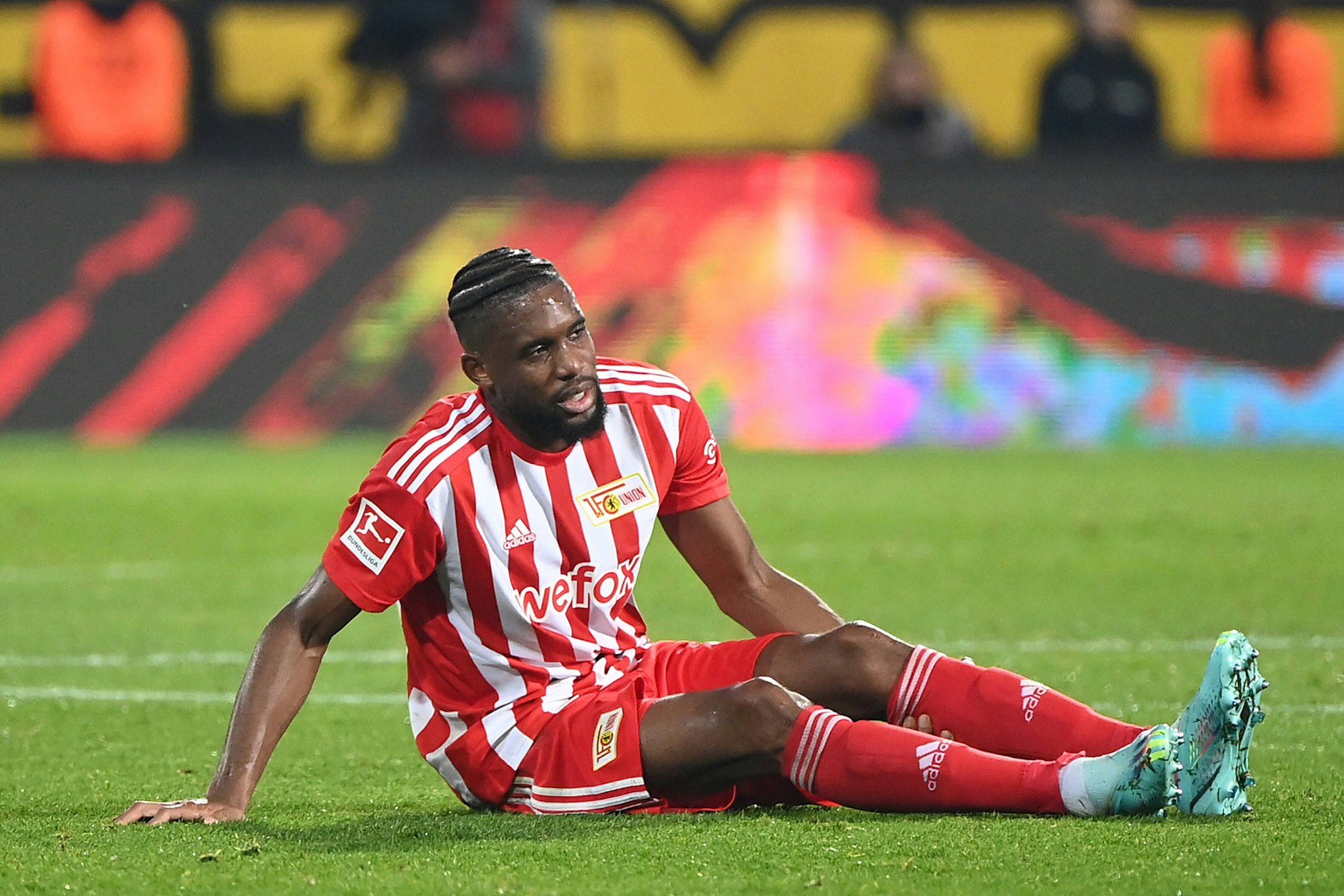 Jordan Siebatcheu sitzt beim Spiel gegen Dortmund auf dem Rasen, humpelt dann wenig später in die Kabine.