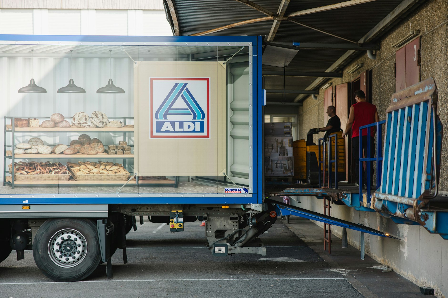 Mitarbeiter beladen einen Lastkraftwagen vor dem Logistikzentrum Aldi Nord. 