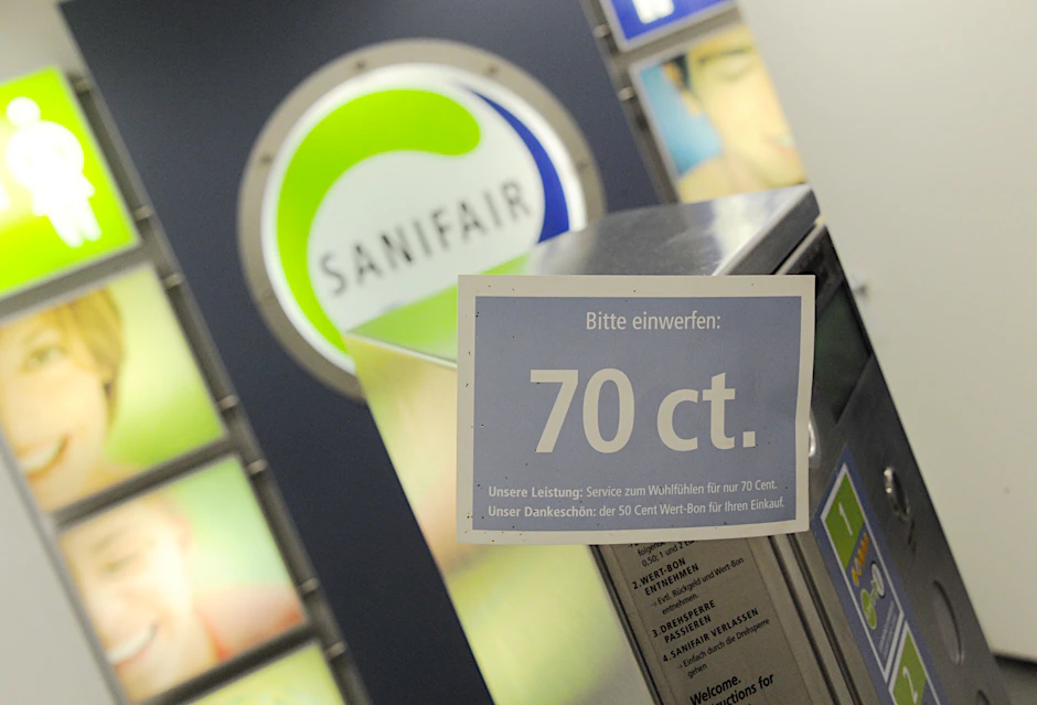 Ein Schild mit der Aufschrift „70 ct“ ist am Automat am Eingangsbereich einer Sanifair-Toilette an einer Autobahn-Tankstelle angebracht.