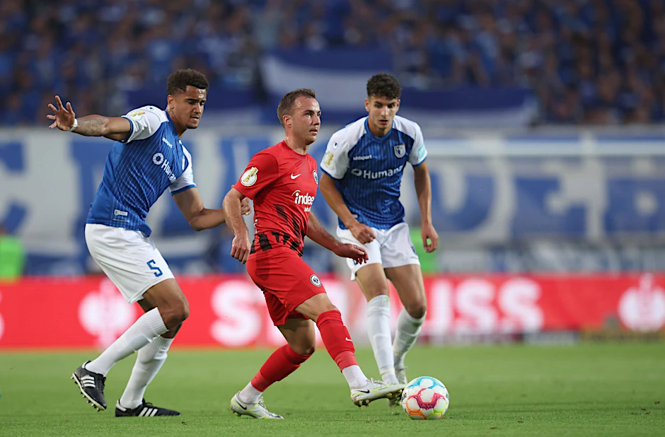 Der Frankfurter Mario Götze (M) spielt gegen die Magdeburger Jamie Lawrence (l) und Daniel Elfadli.  pa