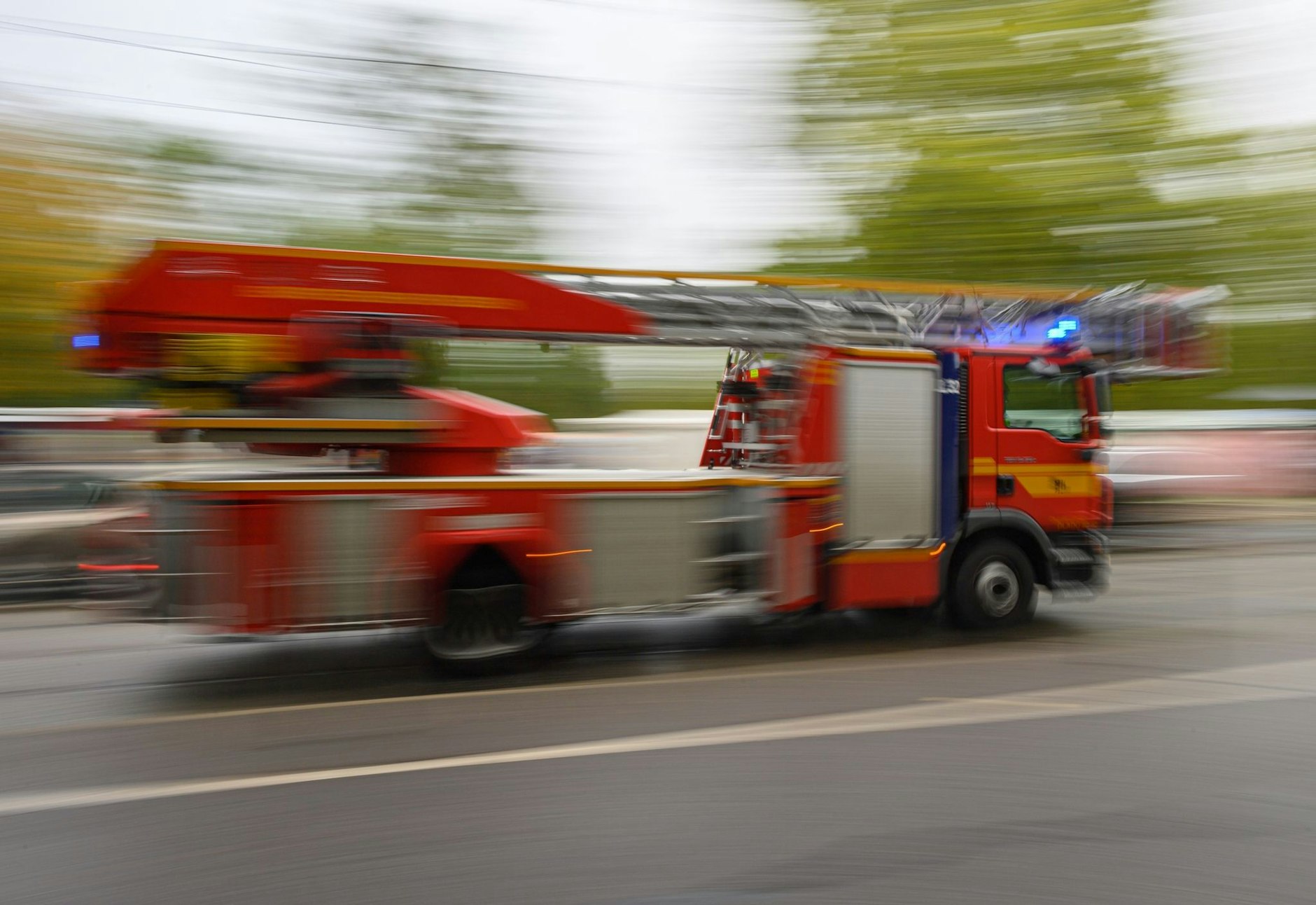 Ein Feuerwehrfahrzeug mit Drehleiter fährt zu einem Einsatz.  B/Symbolbild