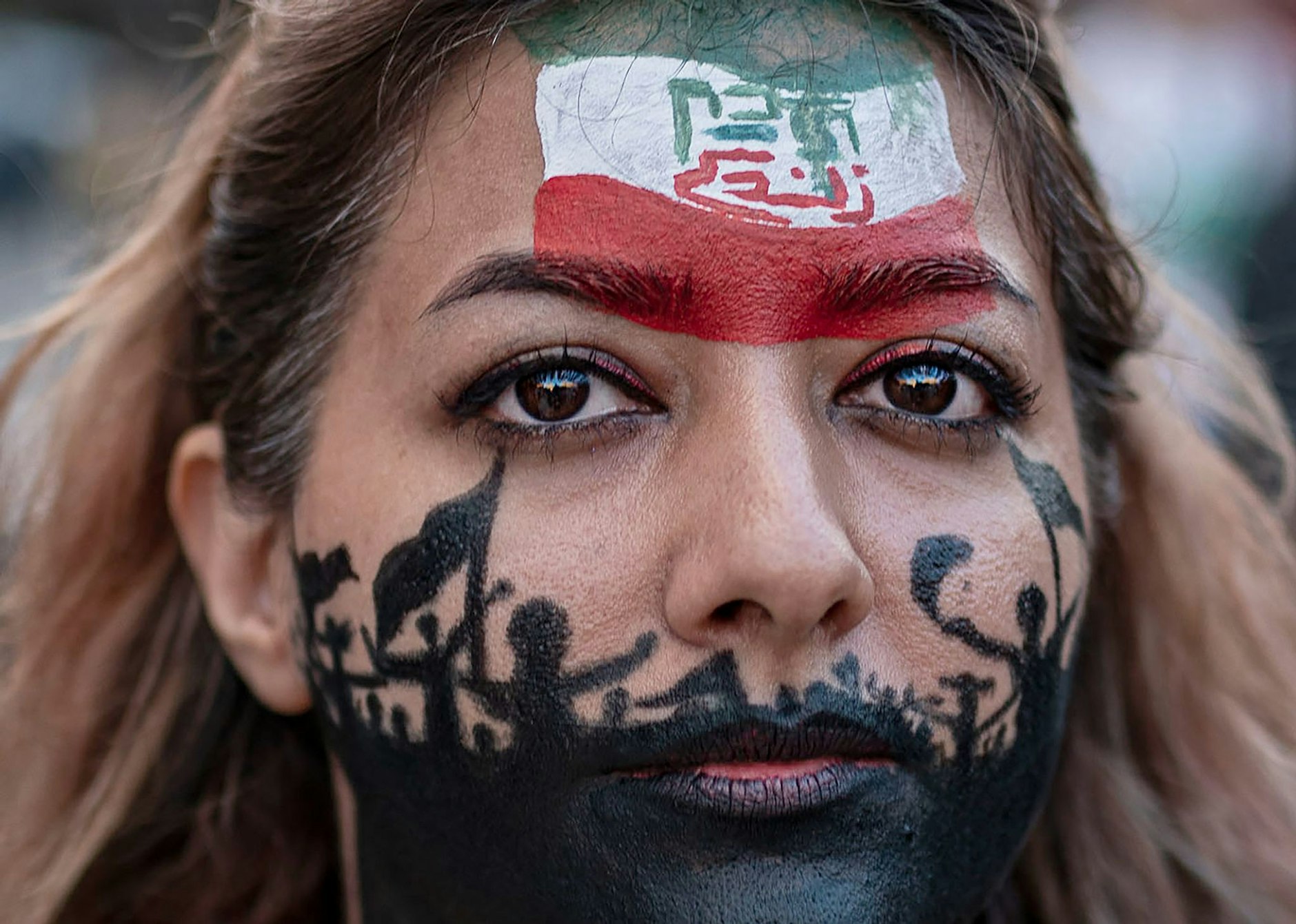 ARCHIV - Eine Frau mit bemaltem Gesicht demonstriert in Barcelona gegen das iranische Regime. Rund 300 Menschen hatten sich in Barcelona versammelt, um für die Rechte der Frauen im Iran zu demonstrieren.  