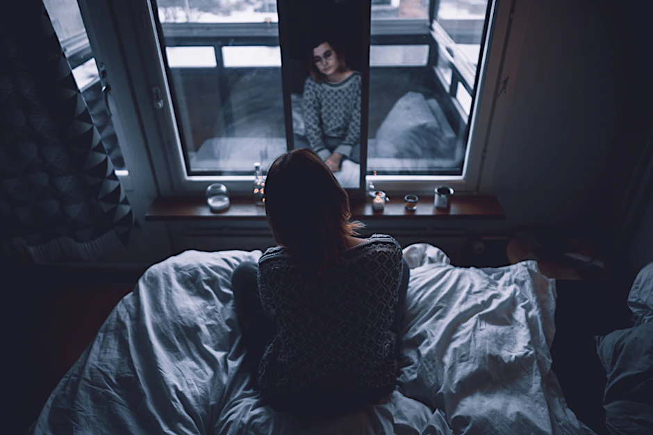 Eine junge Frau sitzt im Bett.&nbsp;