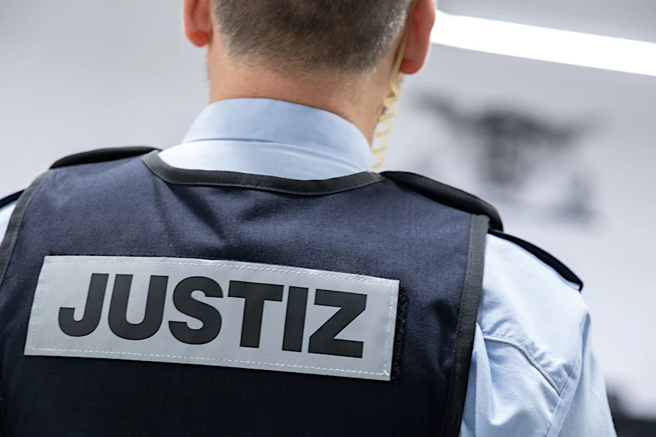 ARCHIV - Ein Justizbeamter steht in einem Gerichtssaal.  