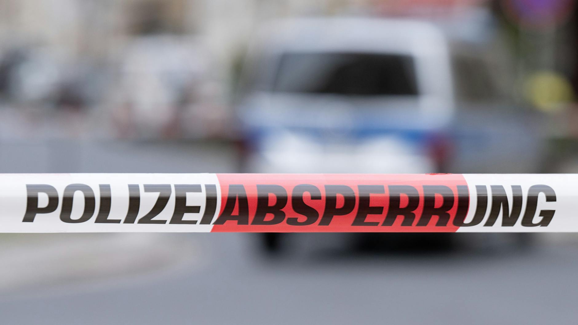 Ein Polizeiauto steht im Dresdner Stadtteil Leipziger Vorstadt auf der Rudolf-Leonhard-Straße hinter einem Absperrband. Wegen eines Mannes mit einer Pistole ist die Polizei zur Sicherung der Lage im Einsatz.