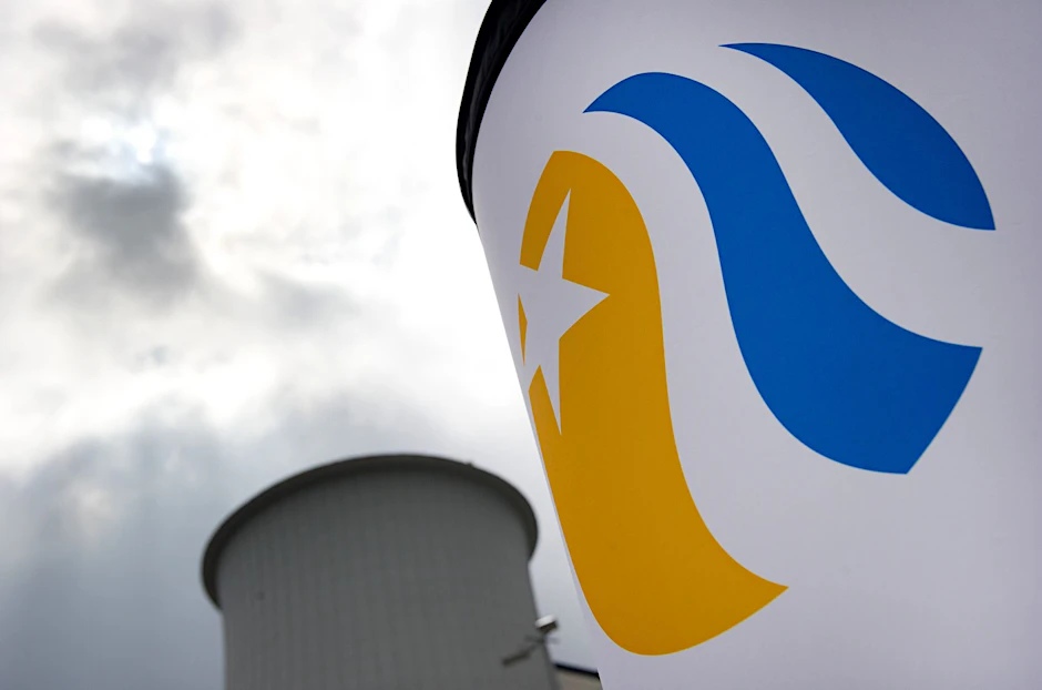 ARCHIV - Hinter einem Vattenfall-Logo ist im Stadtteil Lichterfelde in Berlin ein Abgasturm des Heizkraftwerkes der Vattenfall Europe AG zu sehen.  