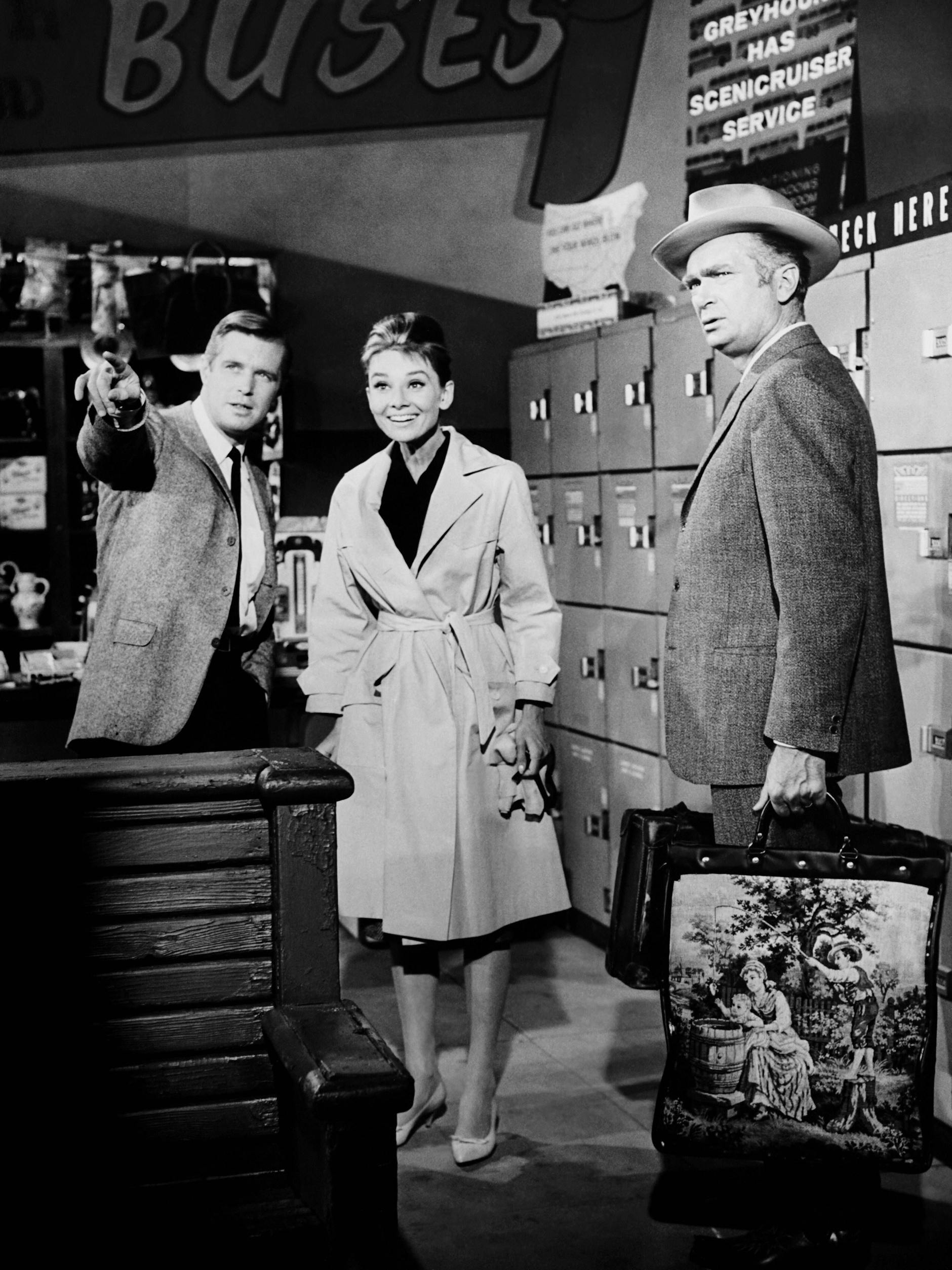 Audrey Hepburn als Holly Golightly im Givenchy-Trench in „Frühstück bei Tiffany“, 1961. Neben ihr George Peppard (links) und Buddy Ebsen.