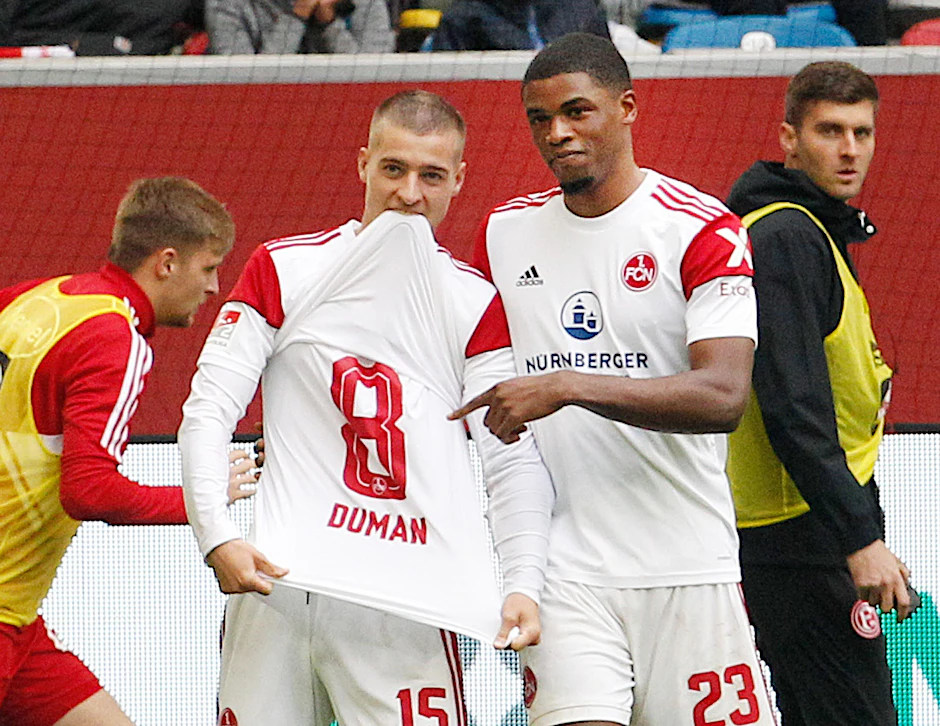 Der Nürnberger Torschütze zum 1:0 Kwadwo Duah (r) jubelt mit Fabian Nürnberger, der ein Trikot von Nürnbergs Duman zeigt.   - Nutzung nur nach schriftlicher Vereinbarung mit der dpa