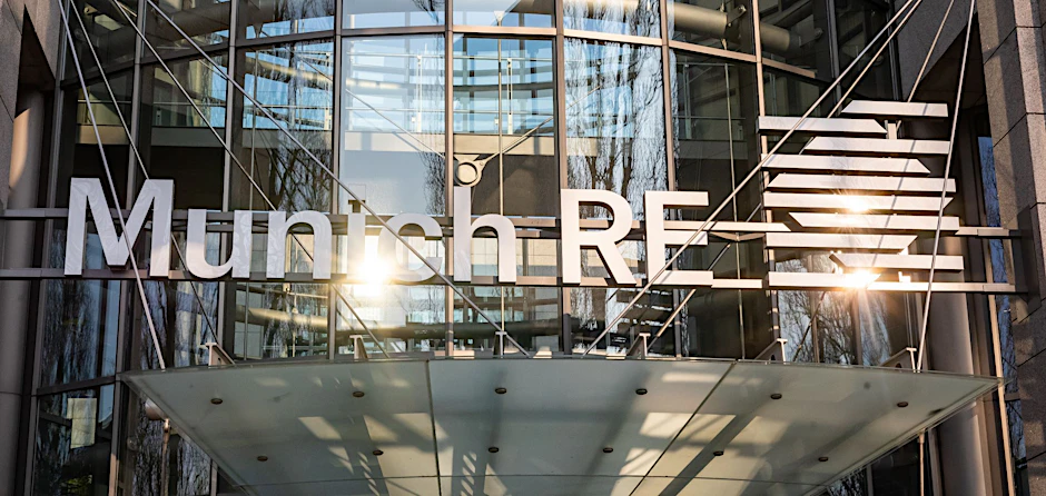 ARCHIV - Das Logo und der Schriftzug der Munich RE am Haupteingang des Verwaltungsgebäudes im Münchner Stadtteil Schwabing.  