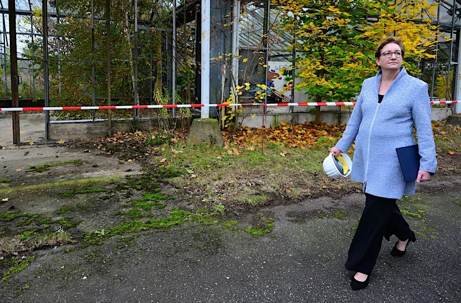 Bundesbauministerin Klara Geywitz geht auf dem Gelände der künftigen «Baumuniversität» an einem ehemaligen Gewächshaus vorbei.  