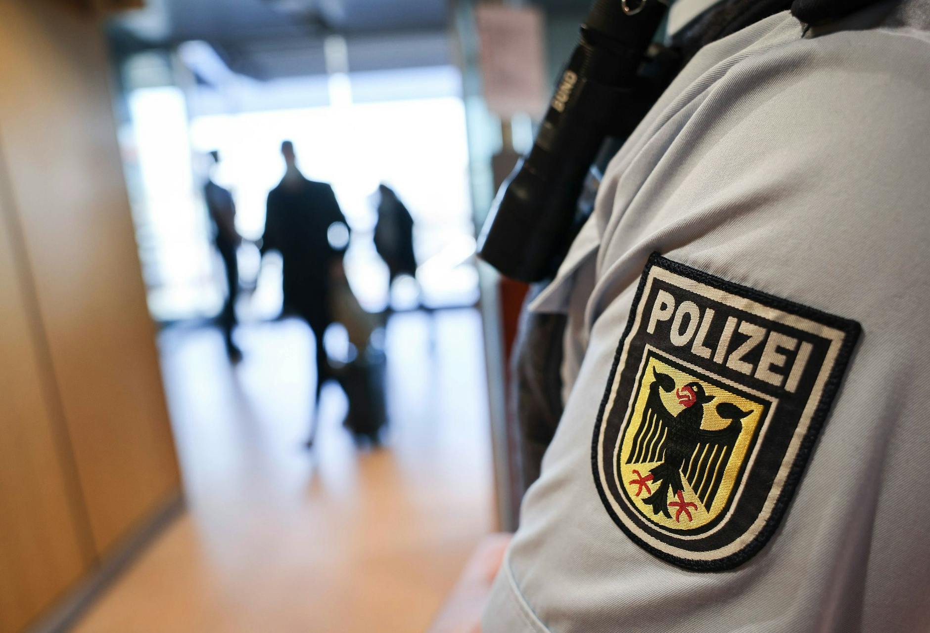 ARCHIV - Ein Beamter der Bundespolizei kontrolliert Reisende am Flughafen. ld