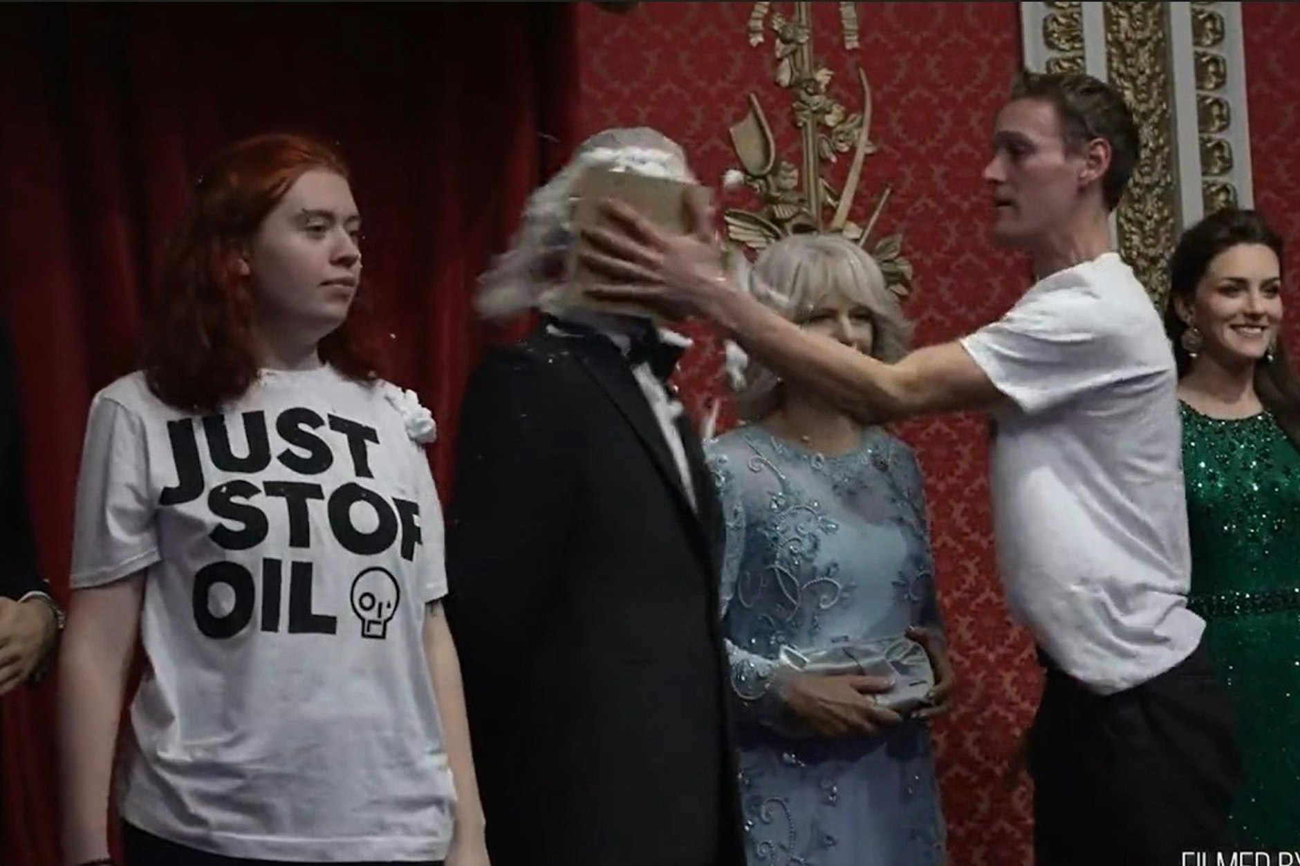 Umweltaktivisten der Gruppe Just Stop Oil bewerfen eine Wachsfigur von König Charles III. mit Schokokuchen.