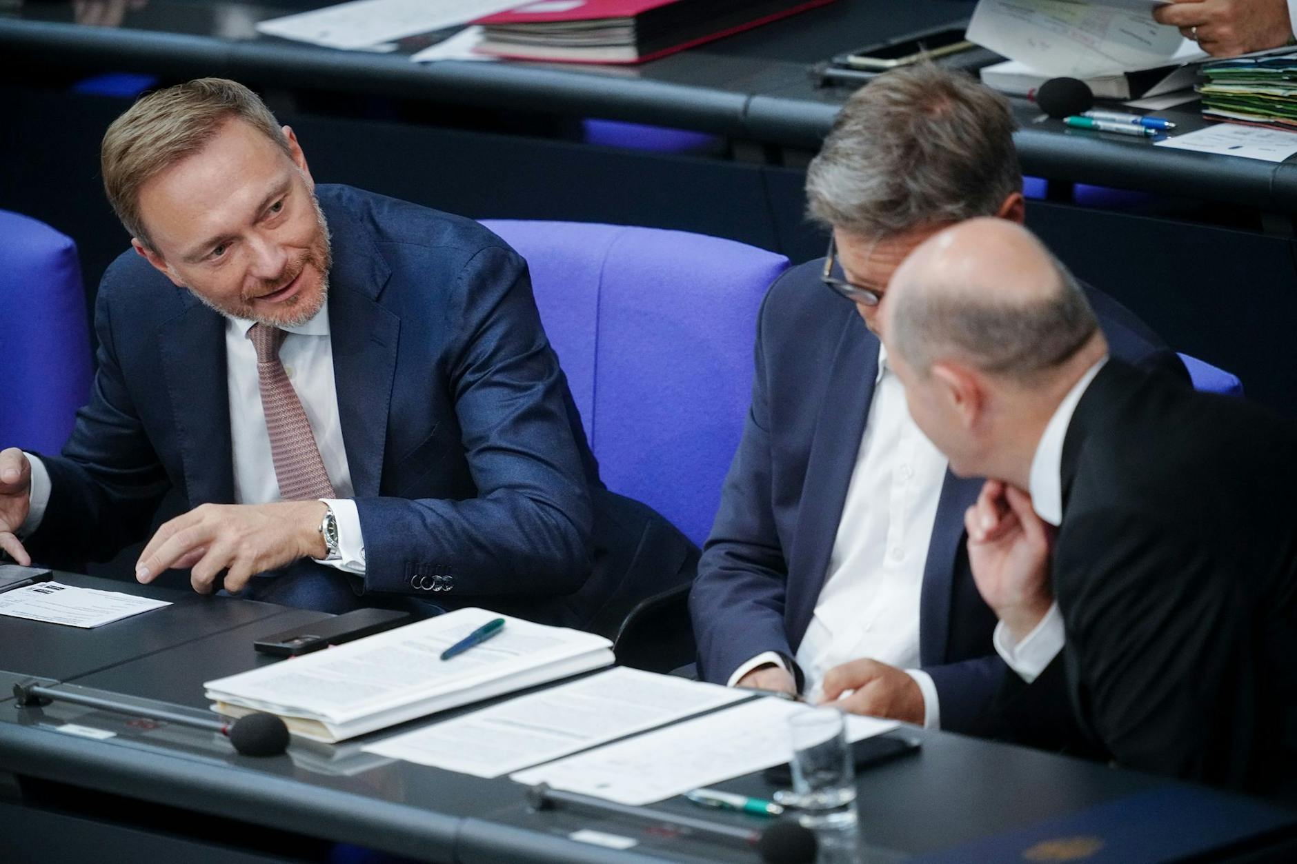 ARCHIV - Finanzminister Christian Lindner (l) spricht mit Bundeskanzler Olaf Scholz (r). Dazwischen sitzt Wirtschaftsminister Robert Habeck (Archivbild).