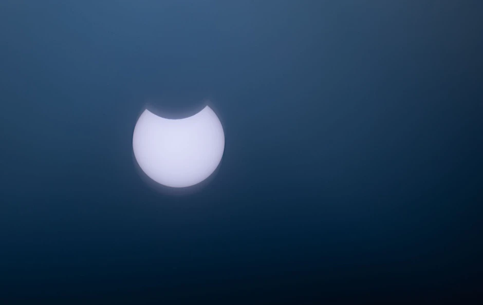 ARCHIV - Ein kleiner Teil der Sonne wird bei der partiellen Sonnenfinsternis vom Mond verdeckt.  
