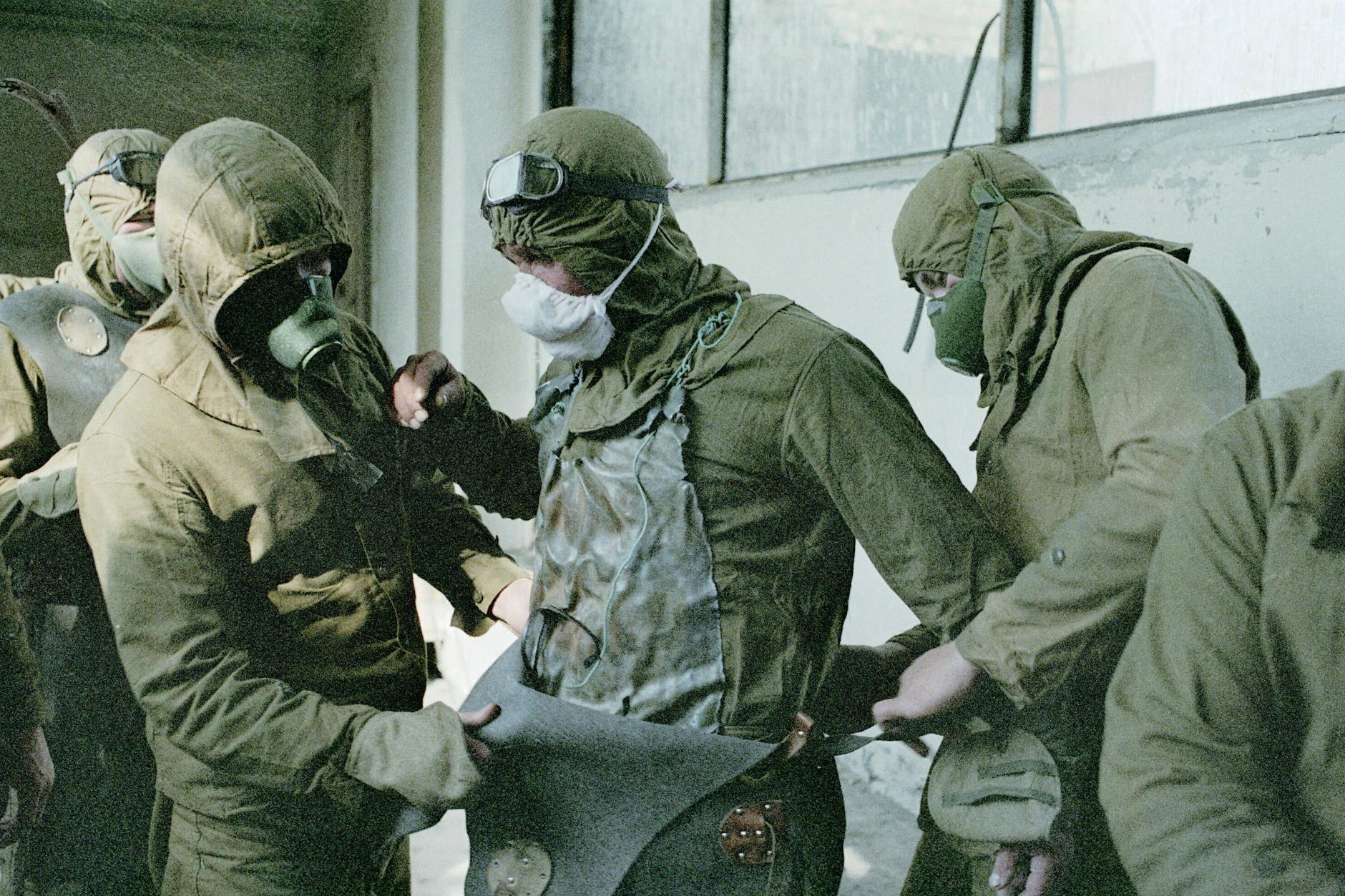 Arbeiter ziehen Schutzanzüge an, um das Dach des Tschernobyl-Reaktors zu reinigen.