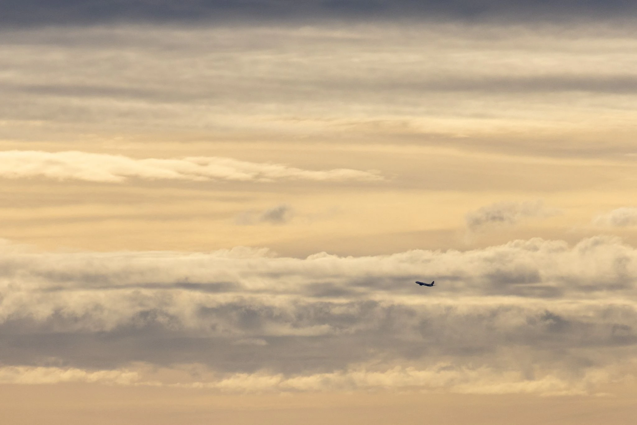 In Bayern startet ein Flugzeug am späten Nachmittag in den Sonnenuntergang hinein.  