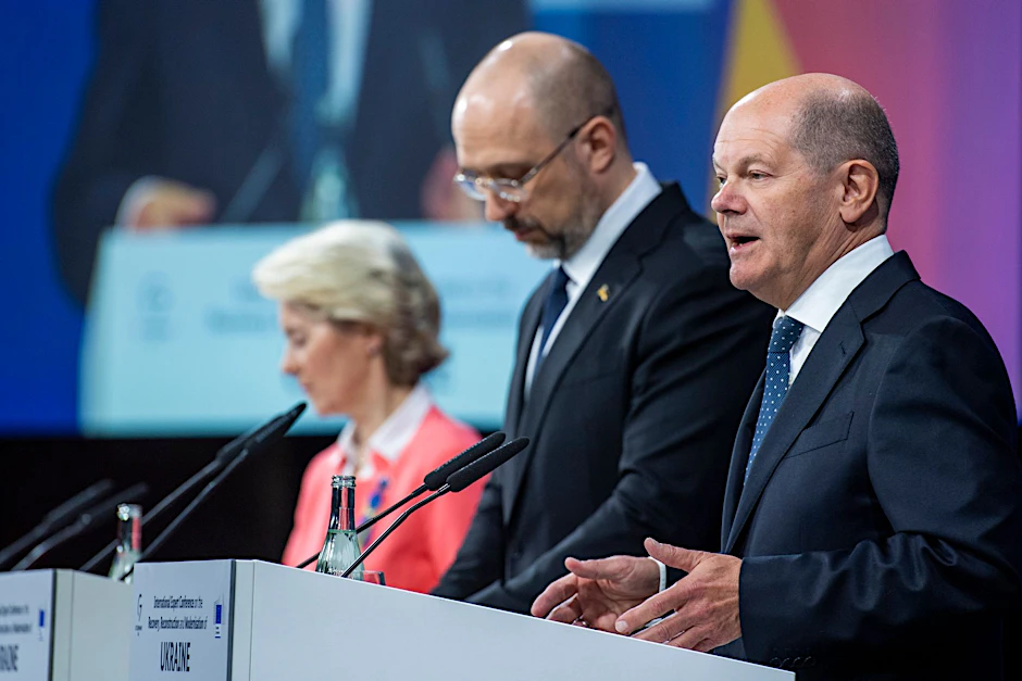 Bundeskanzler Olaf Scholz spricht bei der Expertenkonferenz in Berlin - neben ihm der  ukrainische Ministerpräsident Denys Schmyhal (M) und EU-Kommissionspräsidentin Ursula von der Leyen.  