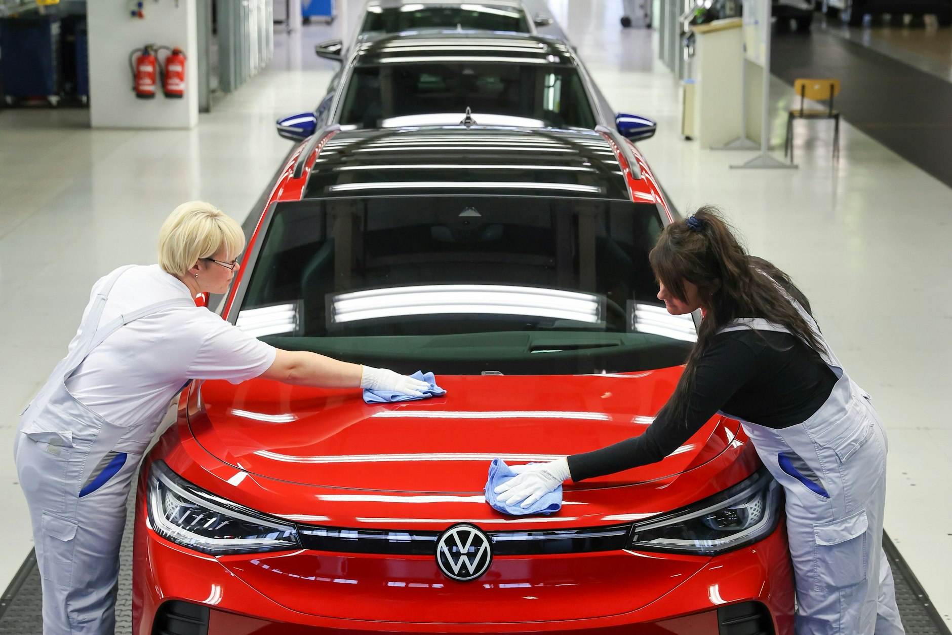 Mitarbeiterinnen prüfen einen ID.4 im Lichttunnel im Werk von Volkswagen in Zwickau.