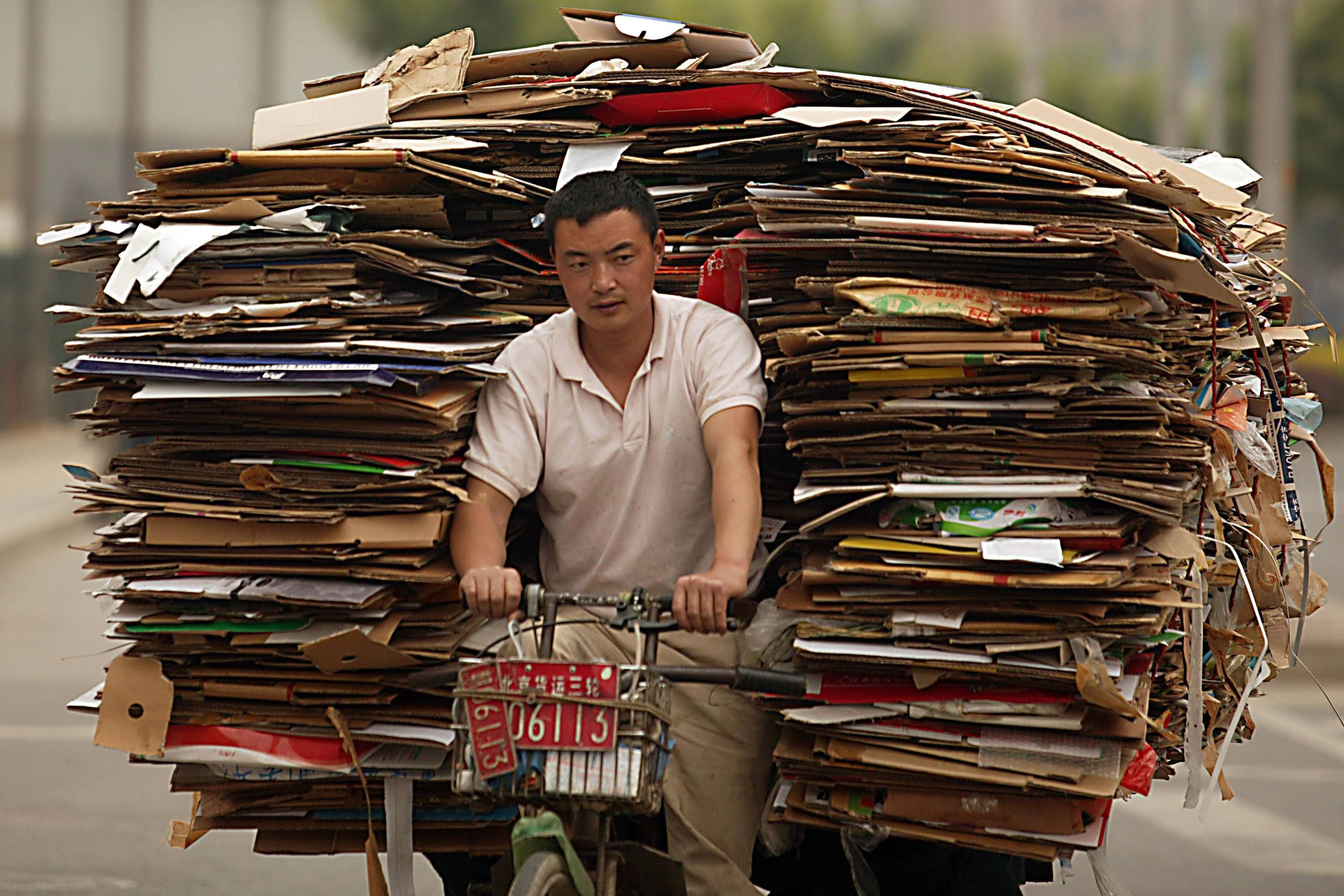 Ein Mann transportiert auf seinem Fahrrad Altpapier in Peking.