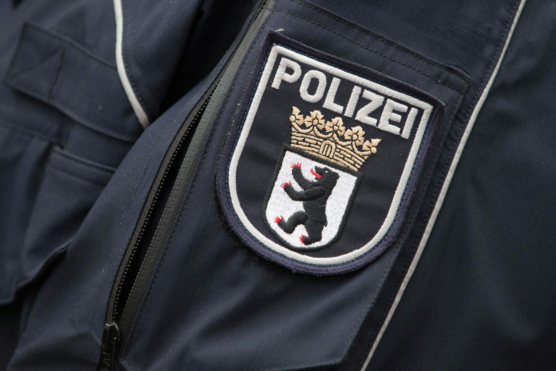 ARCHIV - Das Wappen der Berliner Polizei an einer Polizeijacke. Foto: Tim Brakemeier/dpa/Archivbild