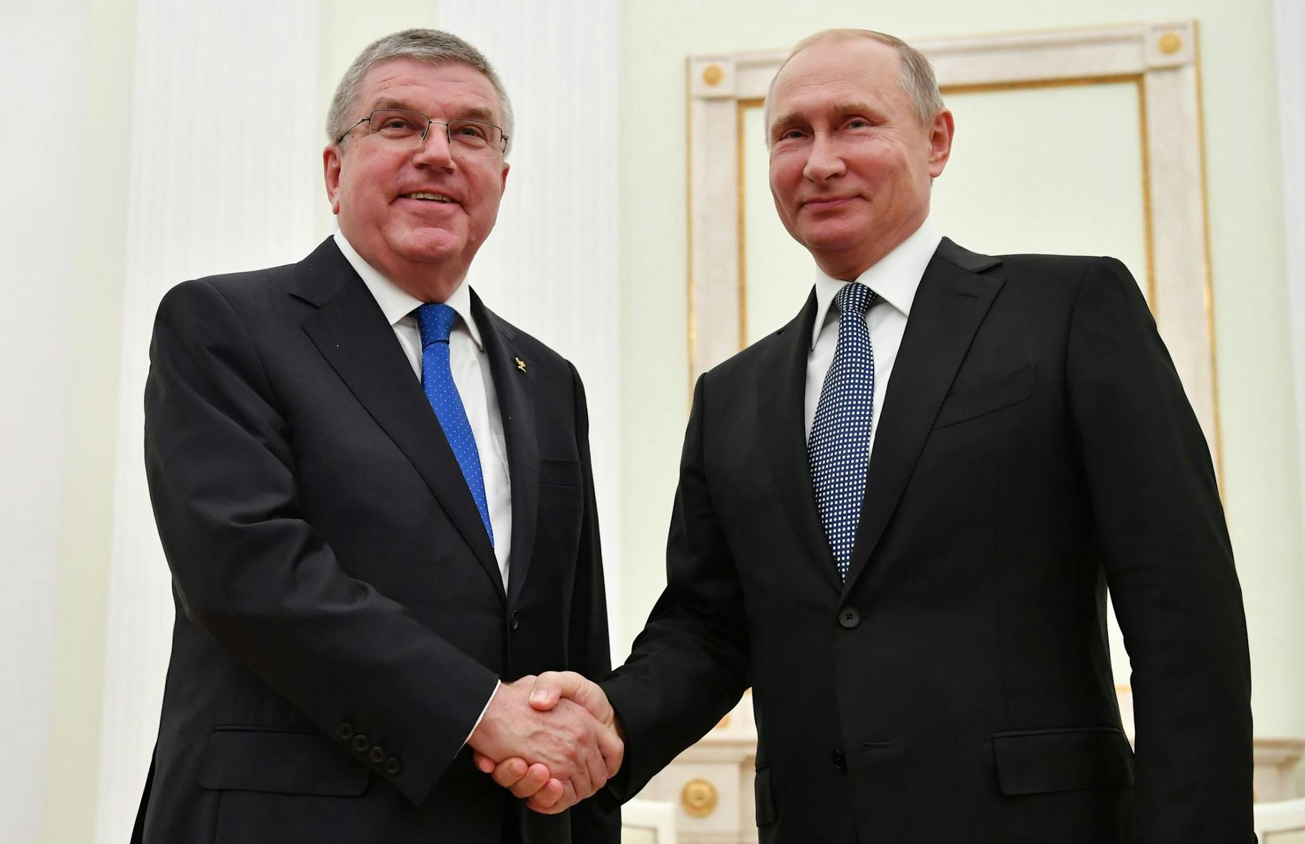 ARCHIV - Russlands Präsident Wladimir Putin (r) und IOC-Chef Thomas Bach.