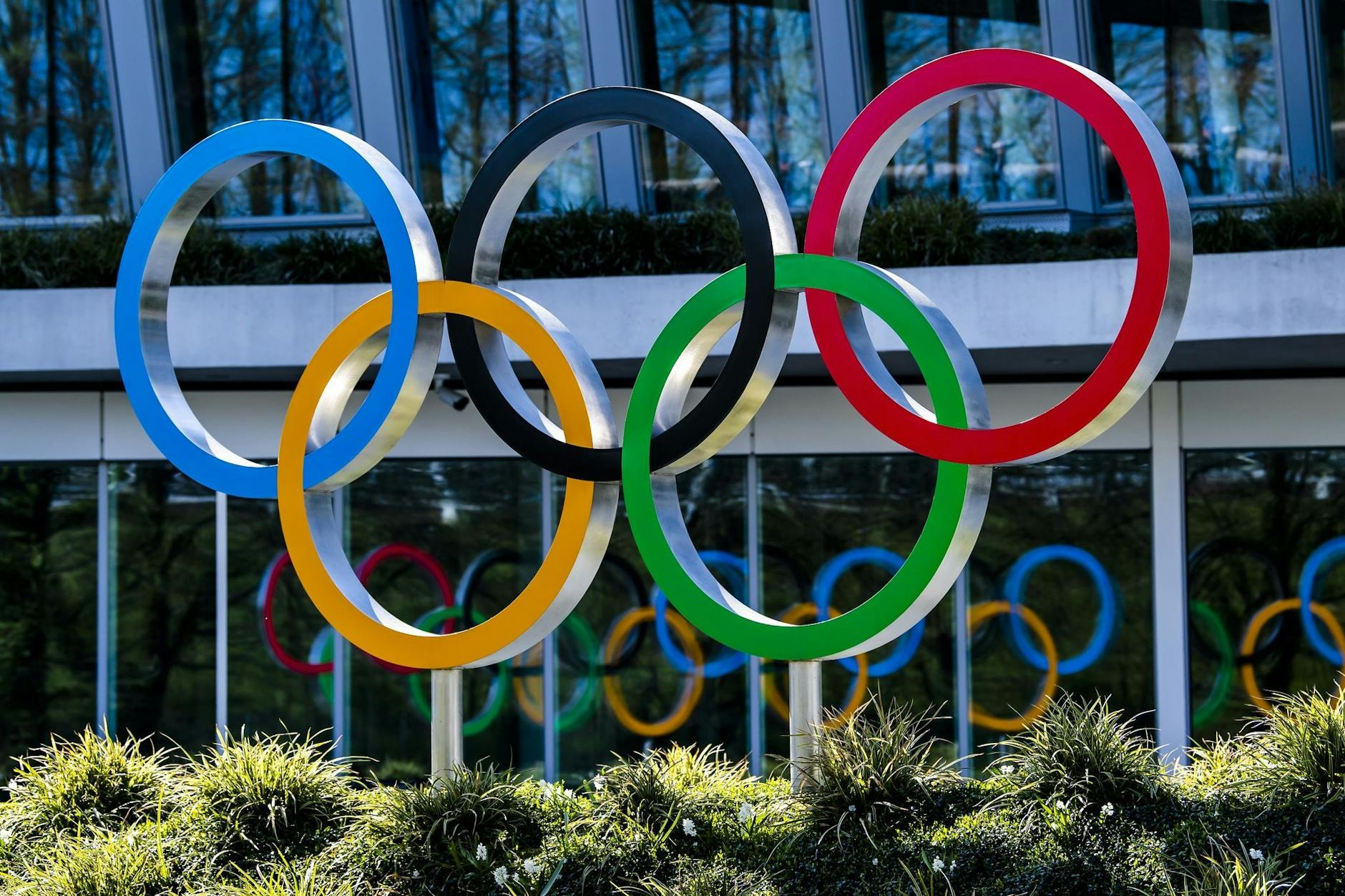 ARCHIV - Die Olympischen Ringe werden am Eingang des IOC, dem Sitz des Internationalen Olympischen Komitees, in Lausanne ausgestellt. a