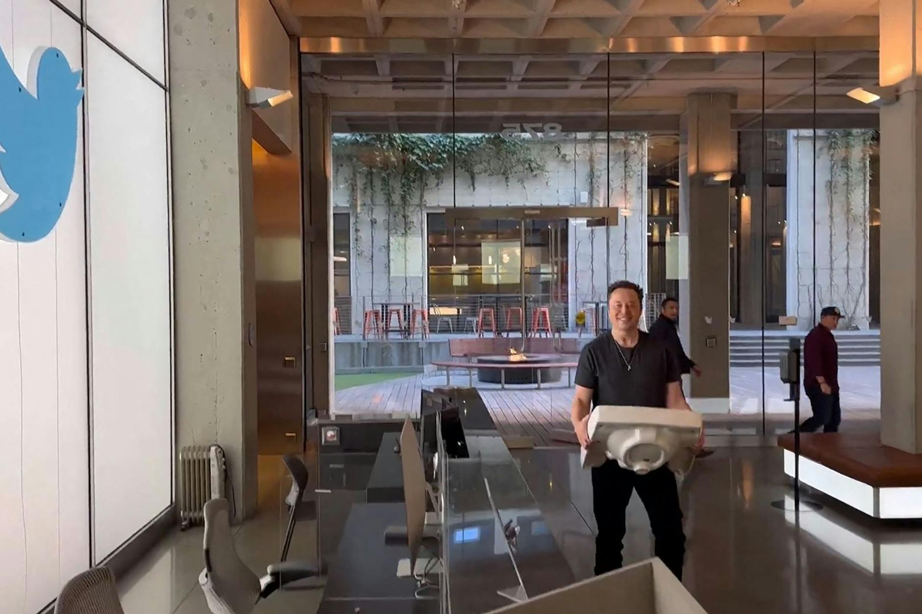 Ein Standbild des Videos zeigt Elon Musk, wie er mit einem Waschbecken in die Twitter-Zentrale läuft.