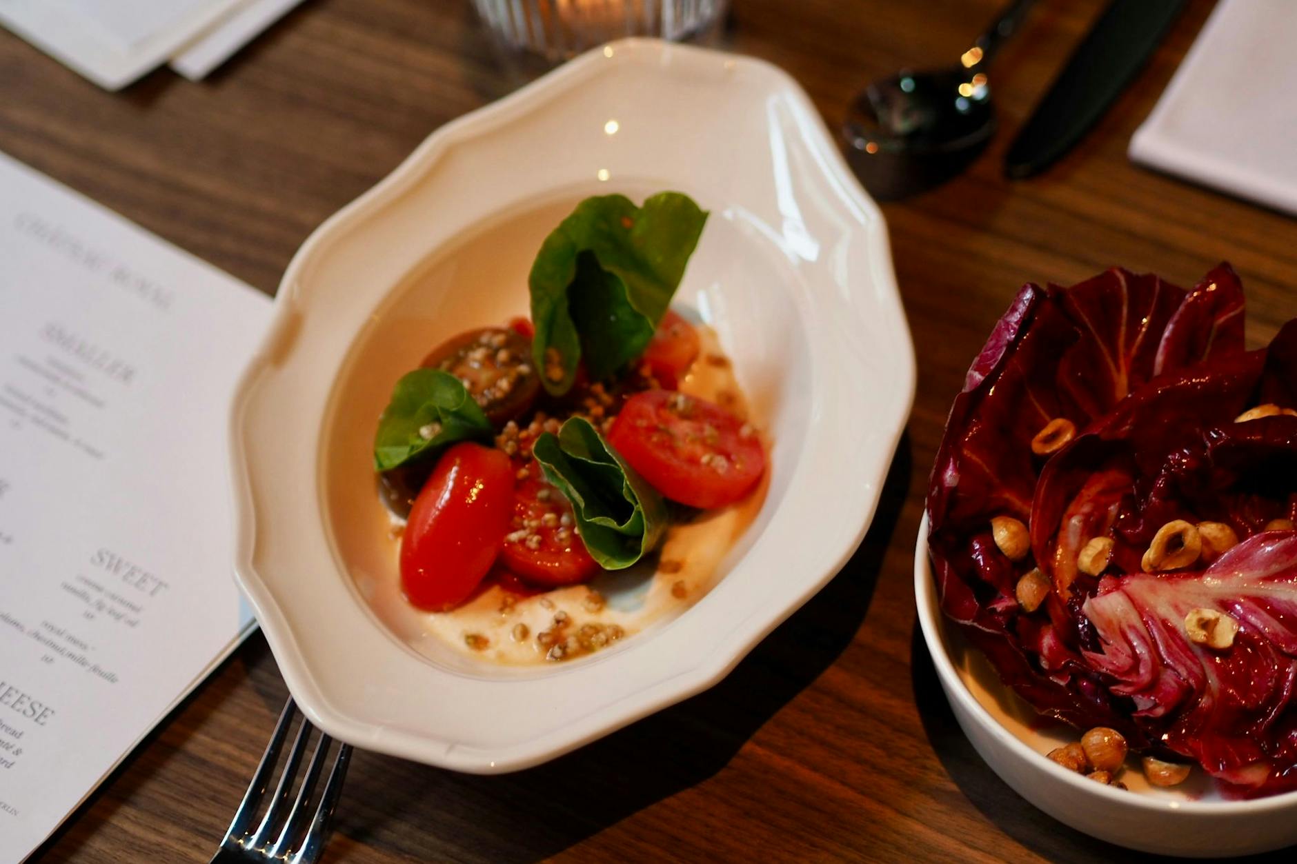 Tomatensalat mit Kamille und einer sahnigen Mandelcreme. Dazu gibt es Radicchio mit Nüssen.