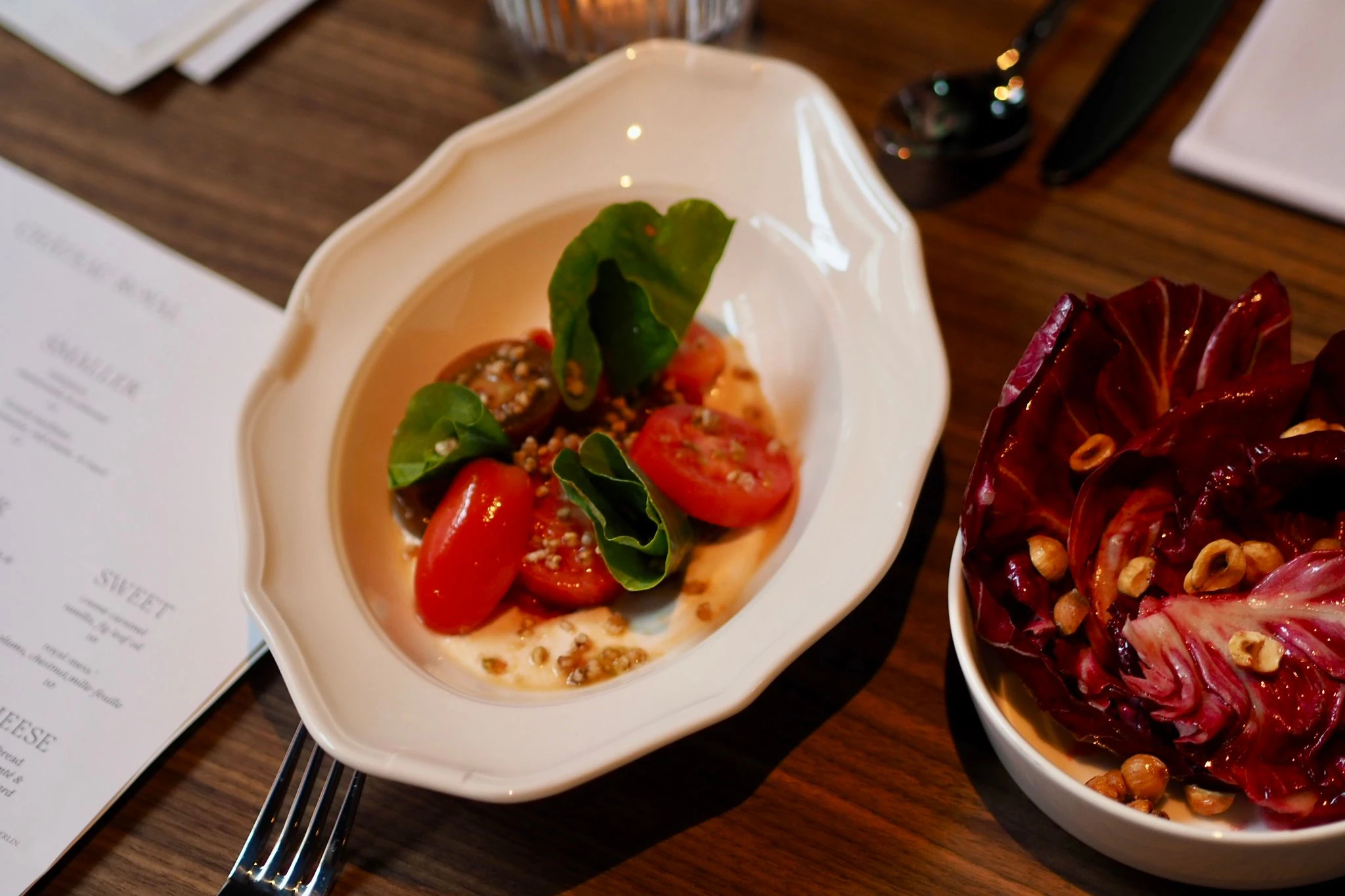 Tomatensalat mit Kamille und einer sahnigen Mandelcreme. Dazu gibt es Radicchio mit Nüssen.
