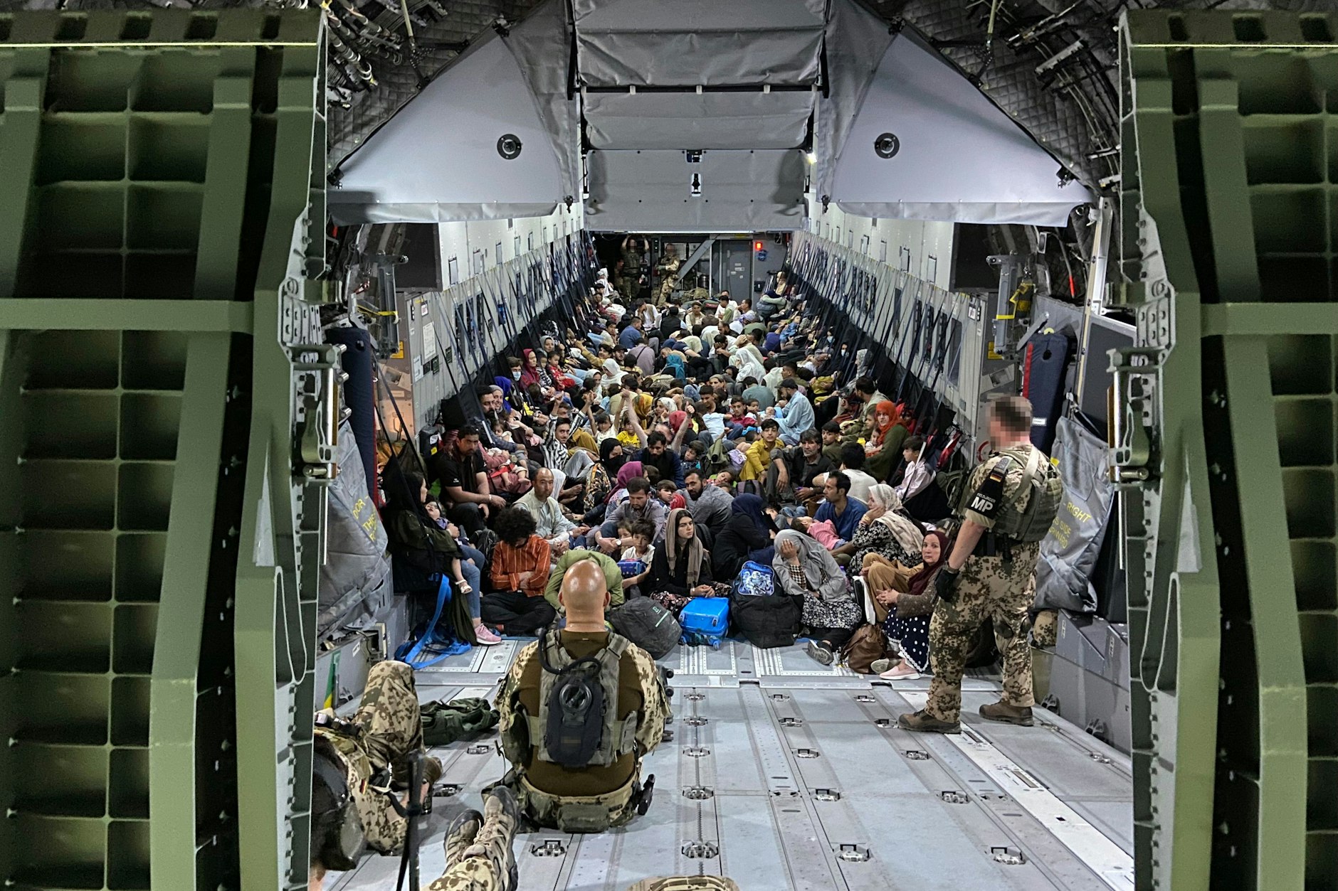 Geflüchtete Afghanen sitzen auf dem Boden in einem Airbus A400M der Bundeswehr.