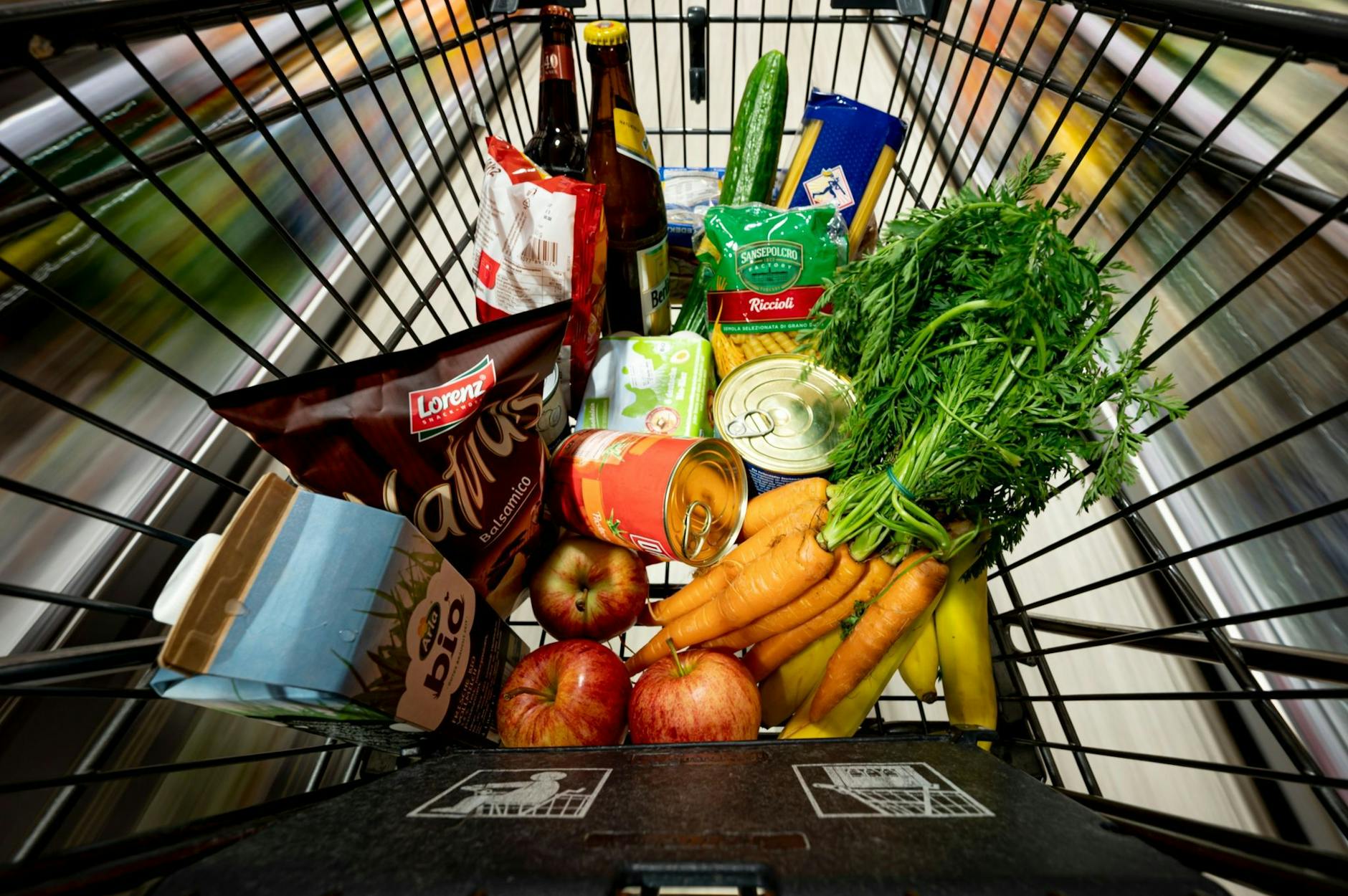 ARCHIV - Lebensmittel liegen in einem Einkaufswagen in einem Supermarkt.