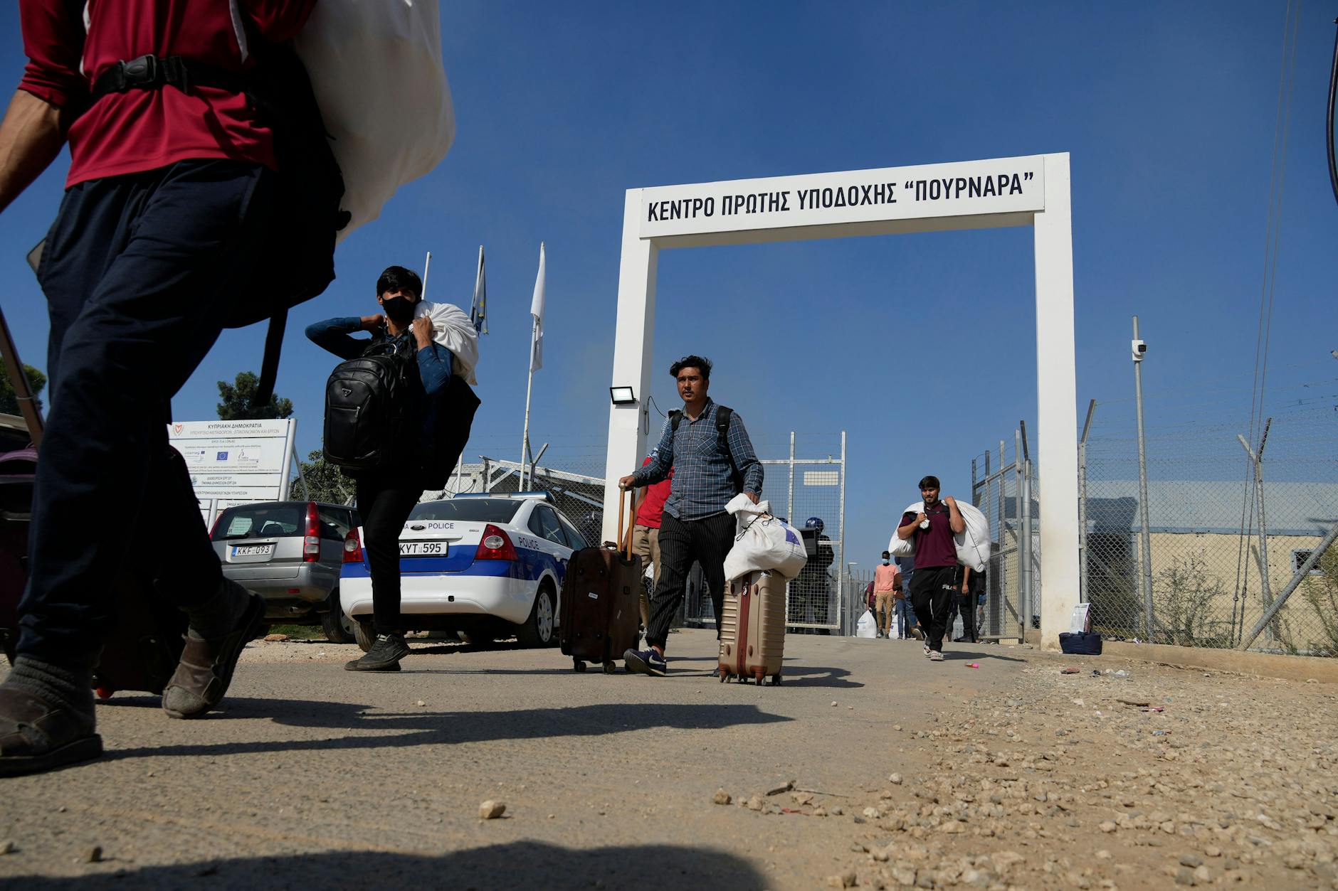 Migranten verlassen das Aufnahmelager mit ihrem Gepäck. Viele suchten Zuflucht in den umliegenden Dörfern.