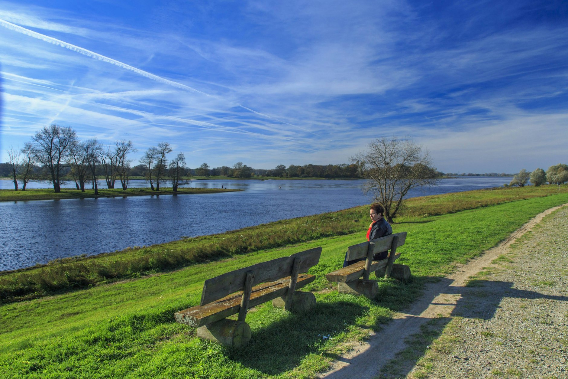 In Rühstädt bei Wittenberge pausiert eine Spaziergängerin an der Elbe. Das Unesco-Biosphärenreservat zieht viele Naturliebhaber an. Mit Fern- und Regionalexpresszügen ist das Elbtal von Berlin aus gut zu erreichen.
