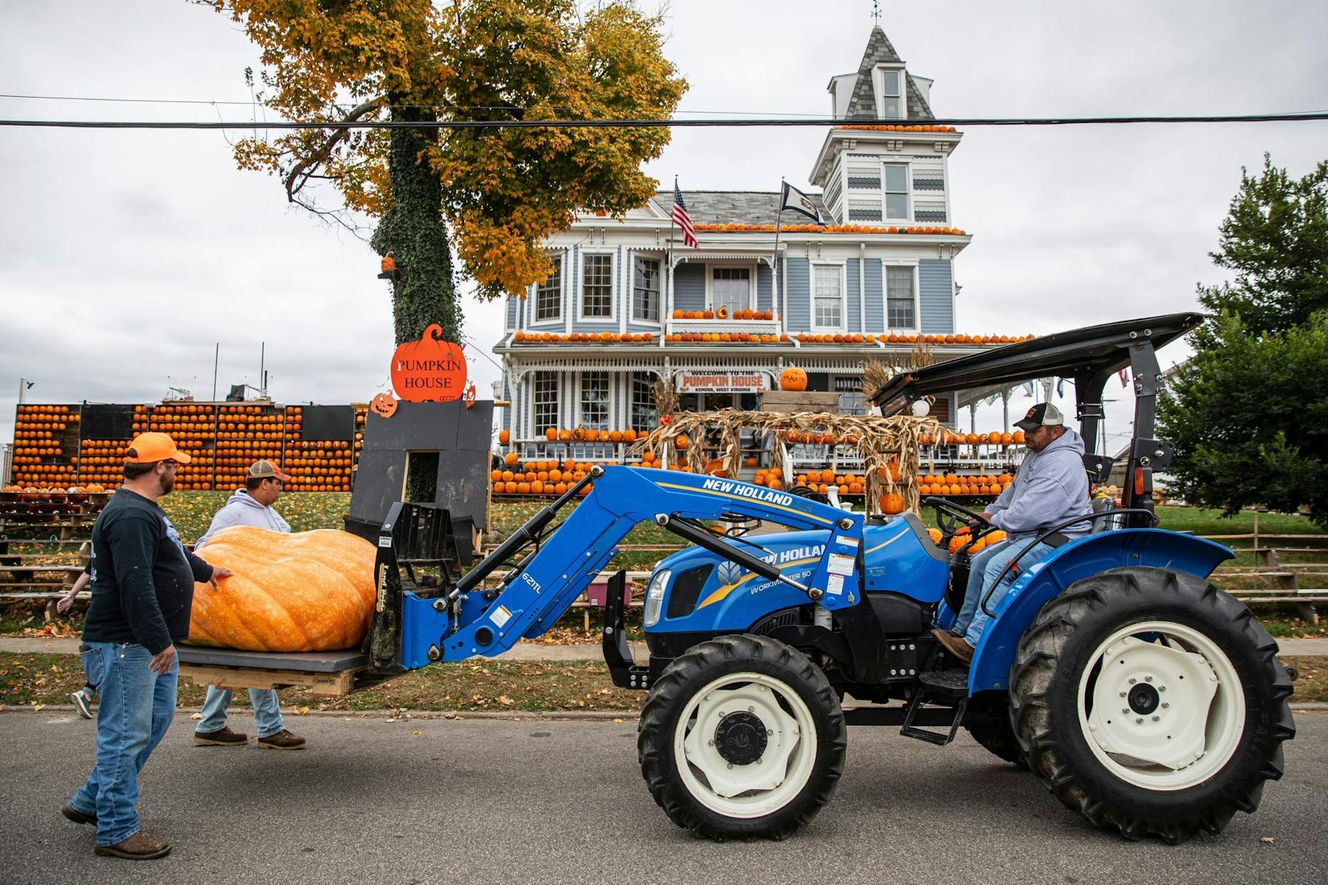 Freiwillige Helfer positionieren einen rund 500 Kilogramm schweren Kürbis vor dem Pumpkin House (Kürbishaus) von Kenova im US-Bundesstaat West Virginia. ch/AP/dpa