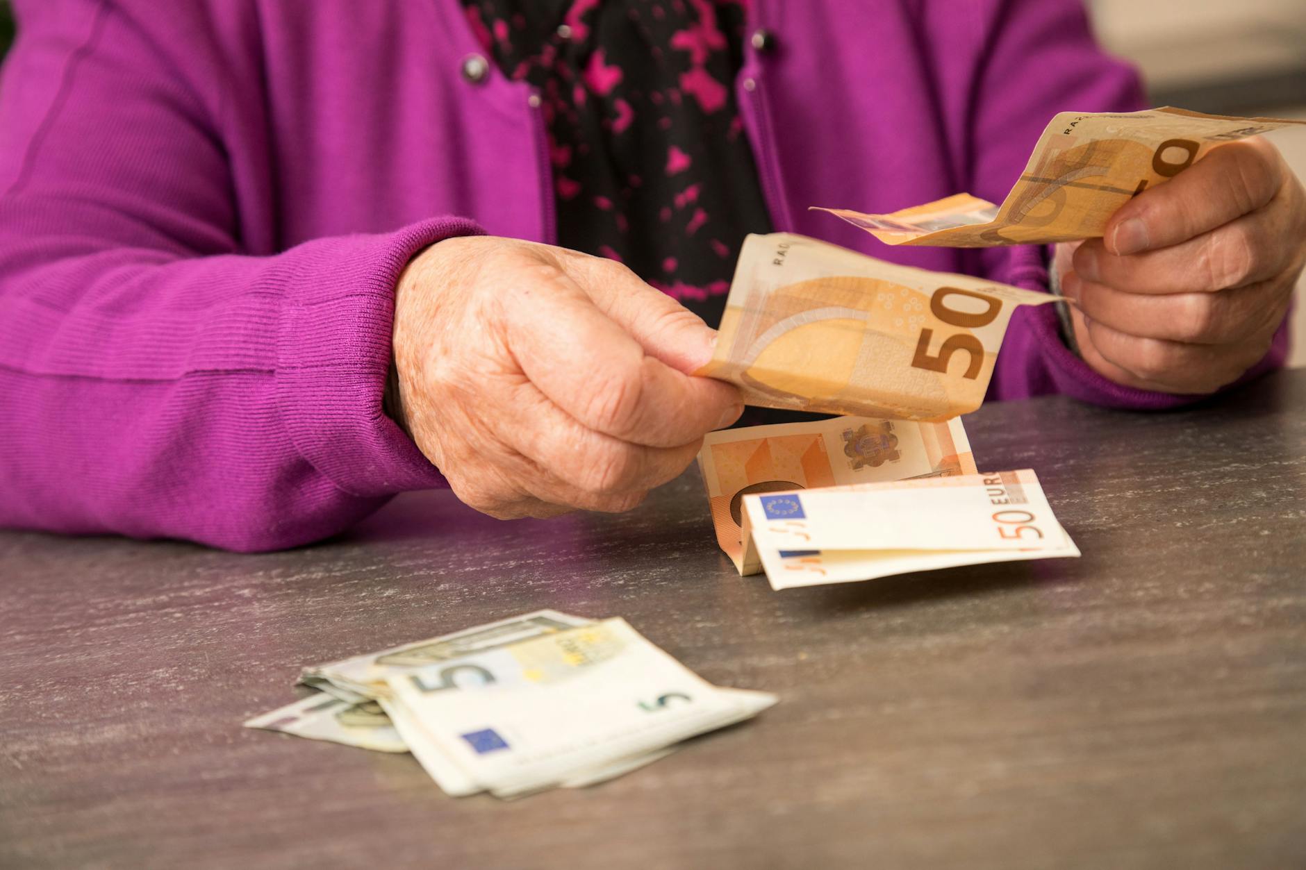 Eine ältere Dame zählt Geld.