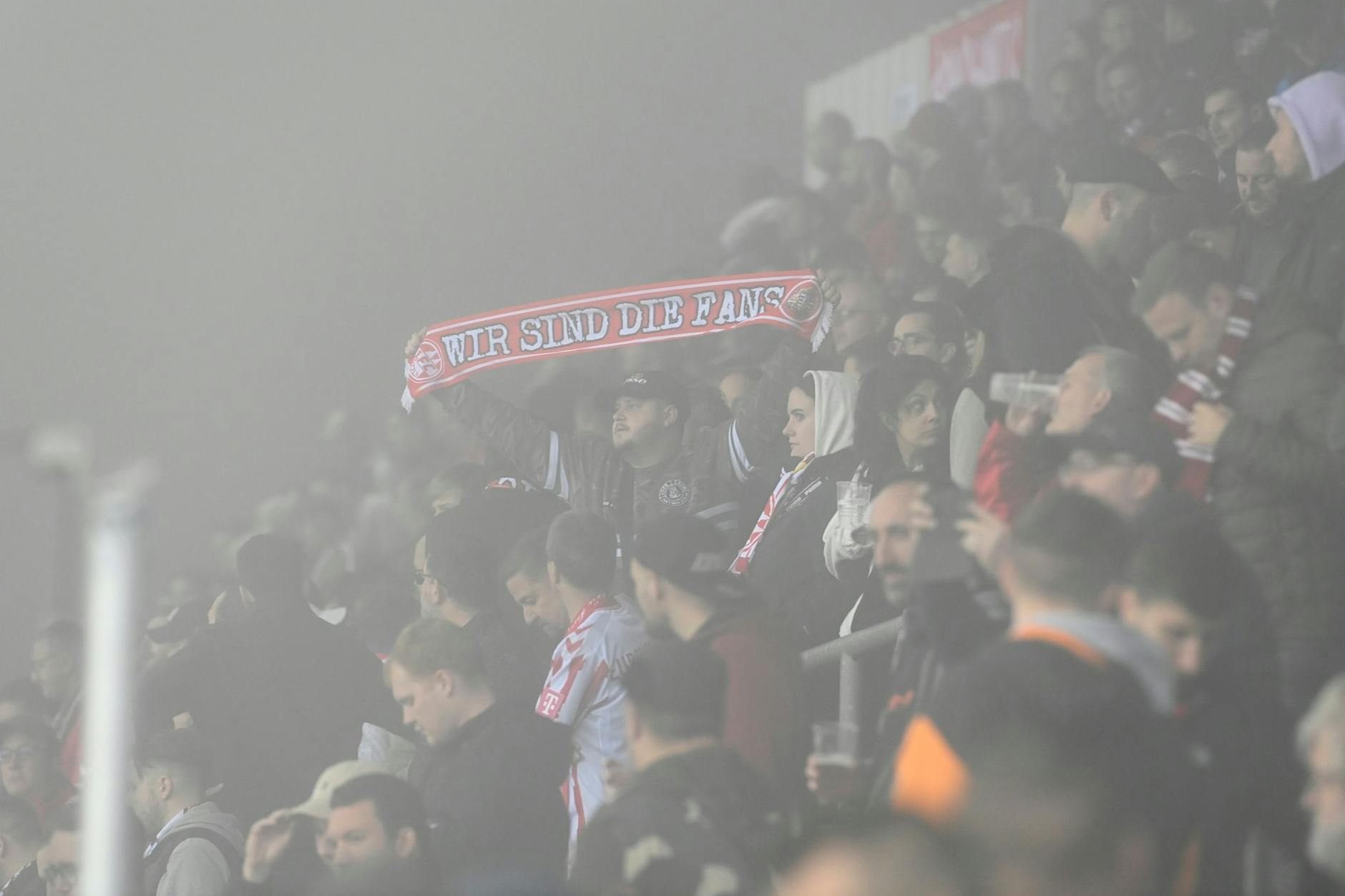 «Wir sind die Fans», steht auf dem Schal eines Anhängers des 1. FC Köln - aber sehen können die nur wenig. Wegen starken Nebels ist die Conference-League-Partie gegen den tschechischen Vertreter 1. FC Slovacko in Uherské Hradi·tenach nach wenigen Minuten abgebrochen worden. Weitergespielt werden soll nun Freitagmittag.