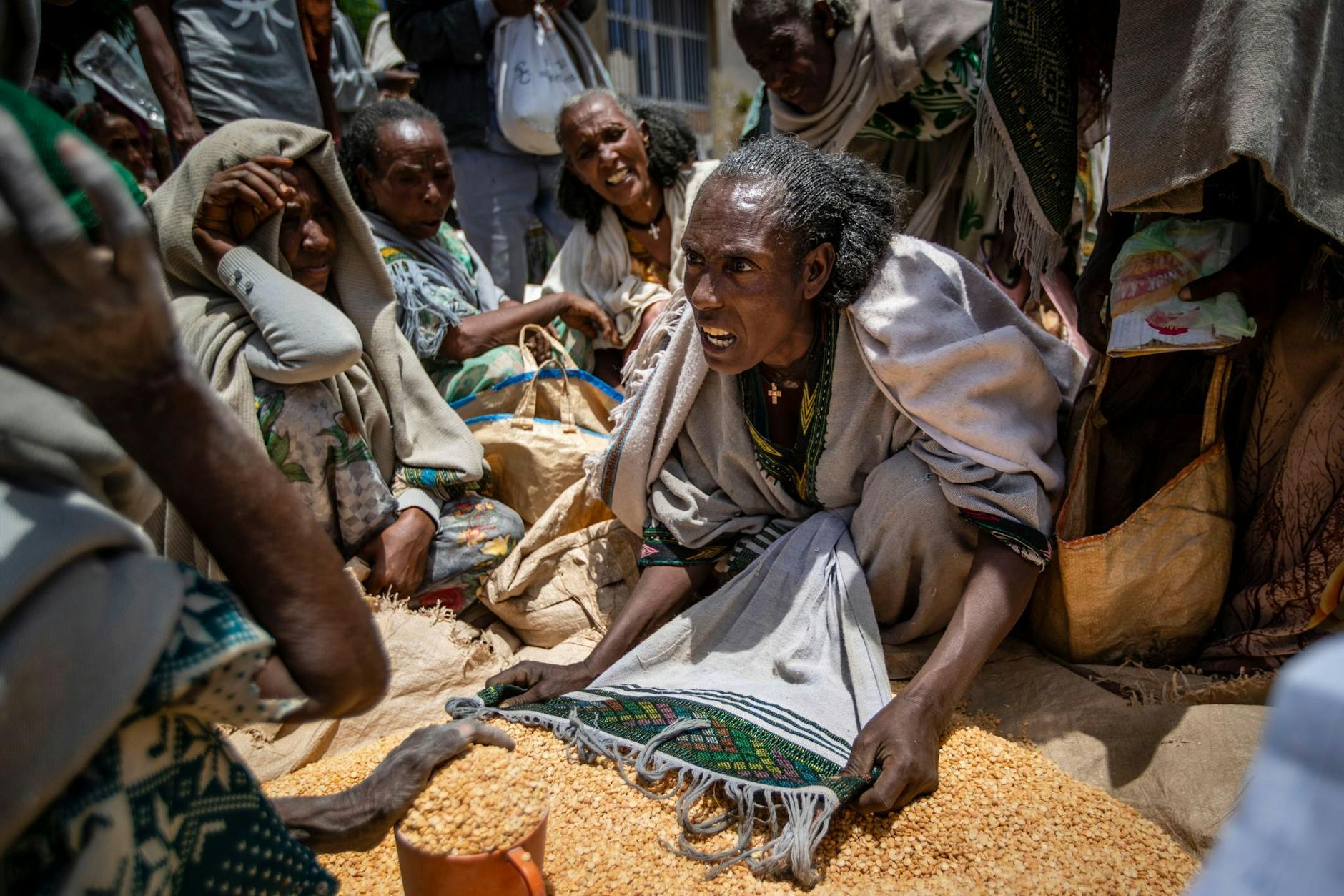 ARCHIV - Eine äthiopische Frau streitet mit anderen über die Verteilung von gelben Spalterbsen, nachdem diese von einer Hilfsorganisation in der Region Tigray verteilt worden waren.