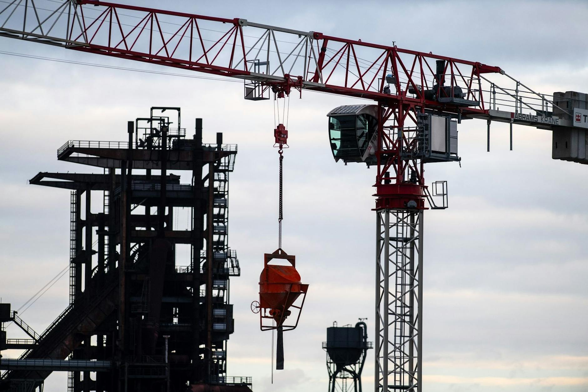 ARCHIV - Ein Baukran steht auf dem Gelände einer Industrieanlage.