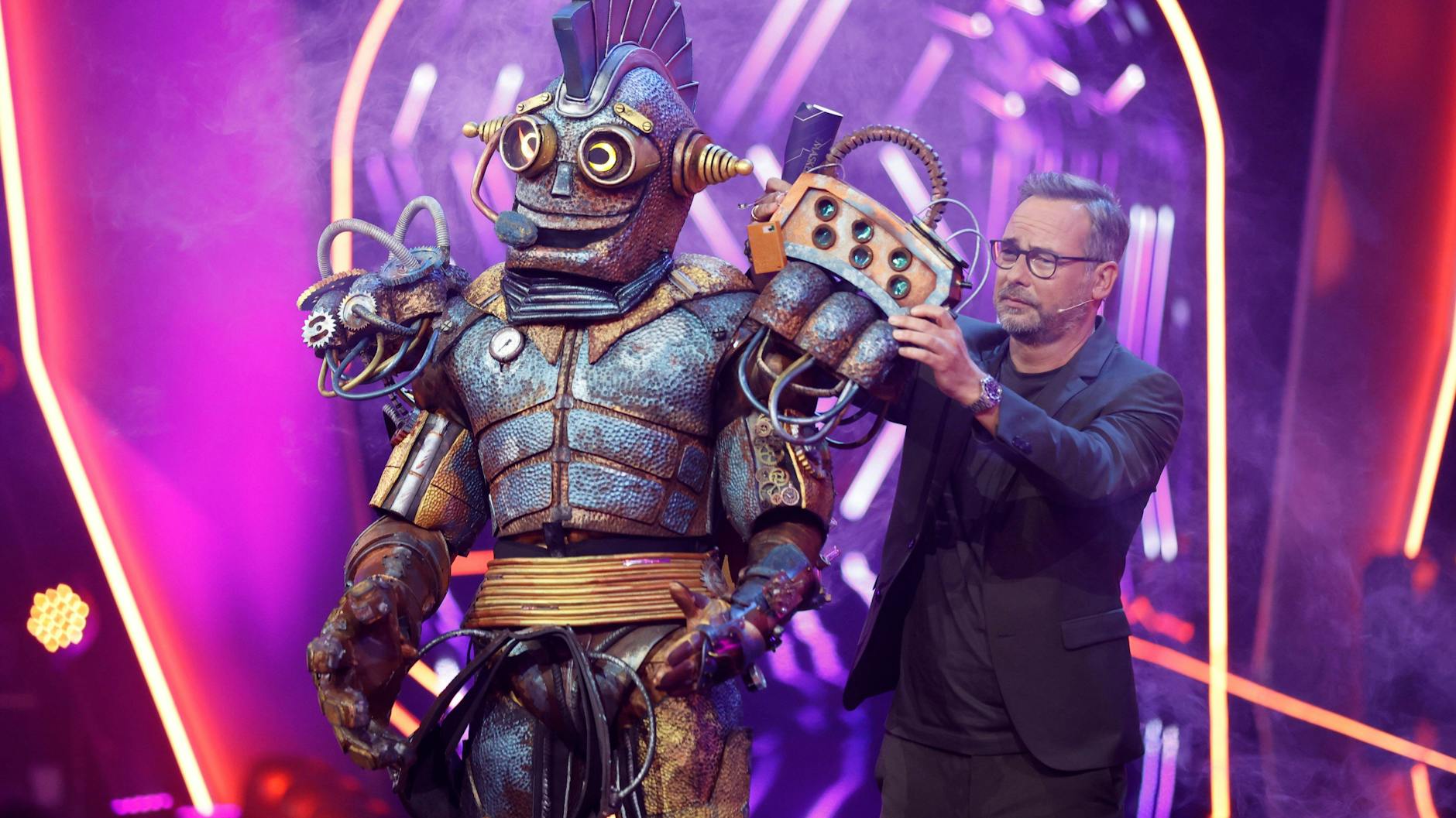 Rosty und Matthias Opdenhövel auf der Bühne von The Masked Singer. Der Blechmann ist einer der Lieblingscharaktere vieler Zuschauer.