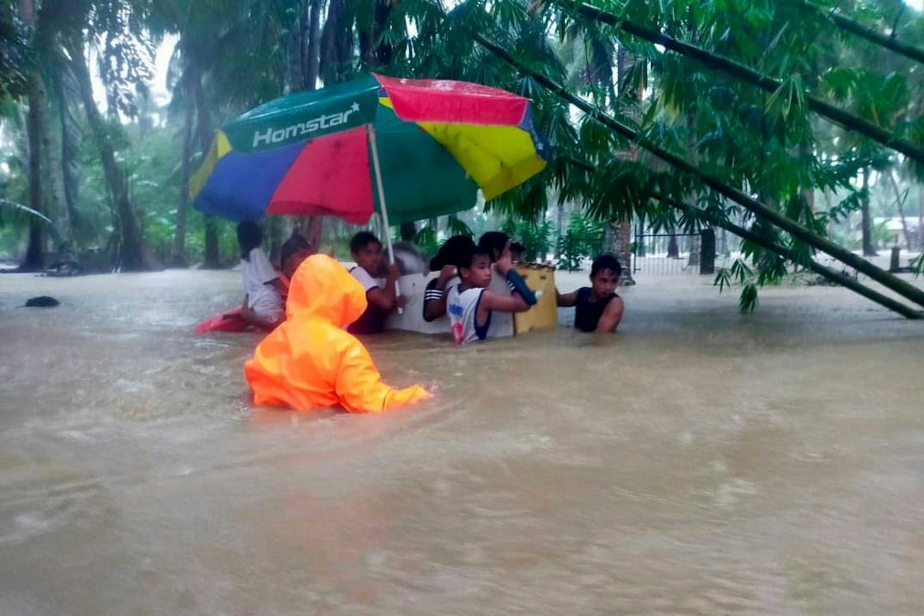 Rettungskräfte verwenden einen alten Kühlschrank als Schwimmkörper, um Bewohner aus den durch den Tropensturm Nalgae verursachten Überschwemmungen in Hilongos, Provinz Leyte, Philippinen, zu evakuieren. d via AP/dpa