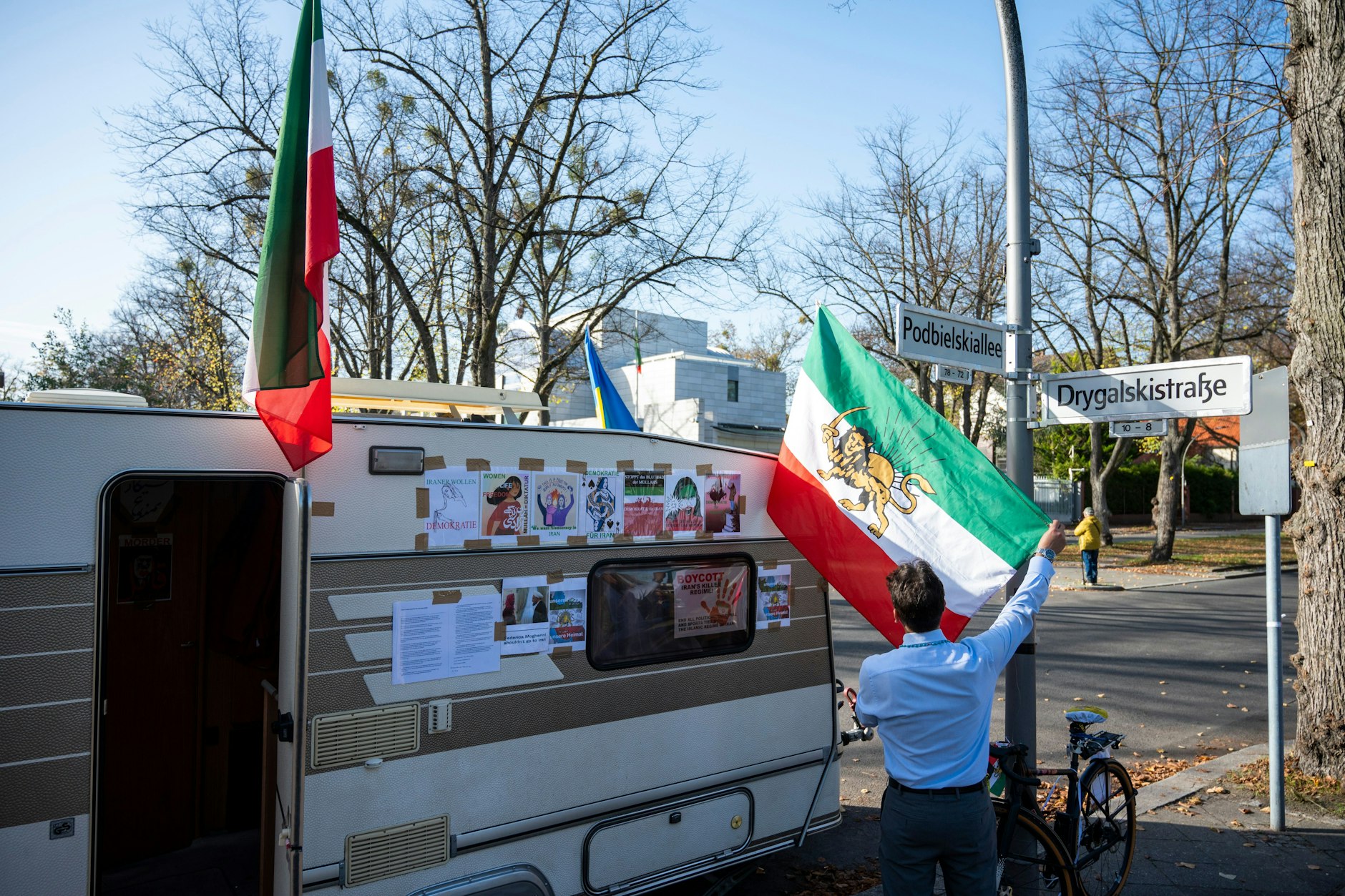 Der Wohnwagen, den Demonstranten als Ort ihrer Mahnwache vor der iranischen  Botschaft auf der anderen Seite der Podbielskiallee abgestellt haben.