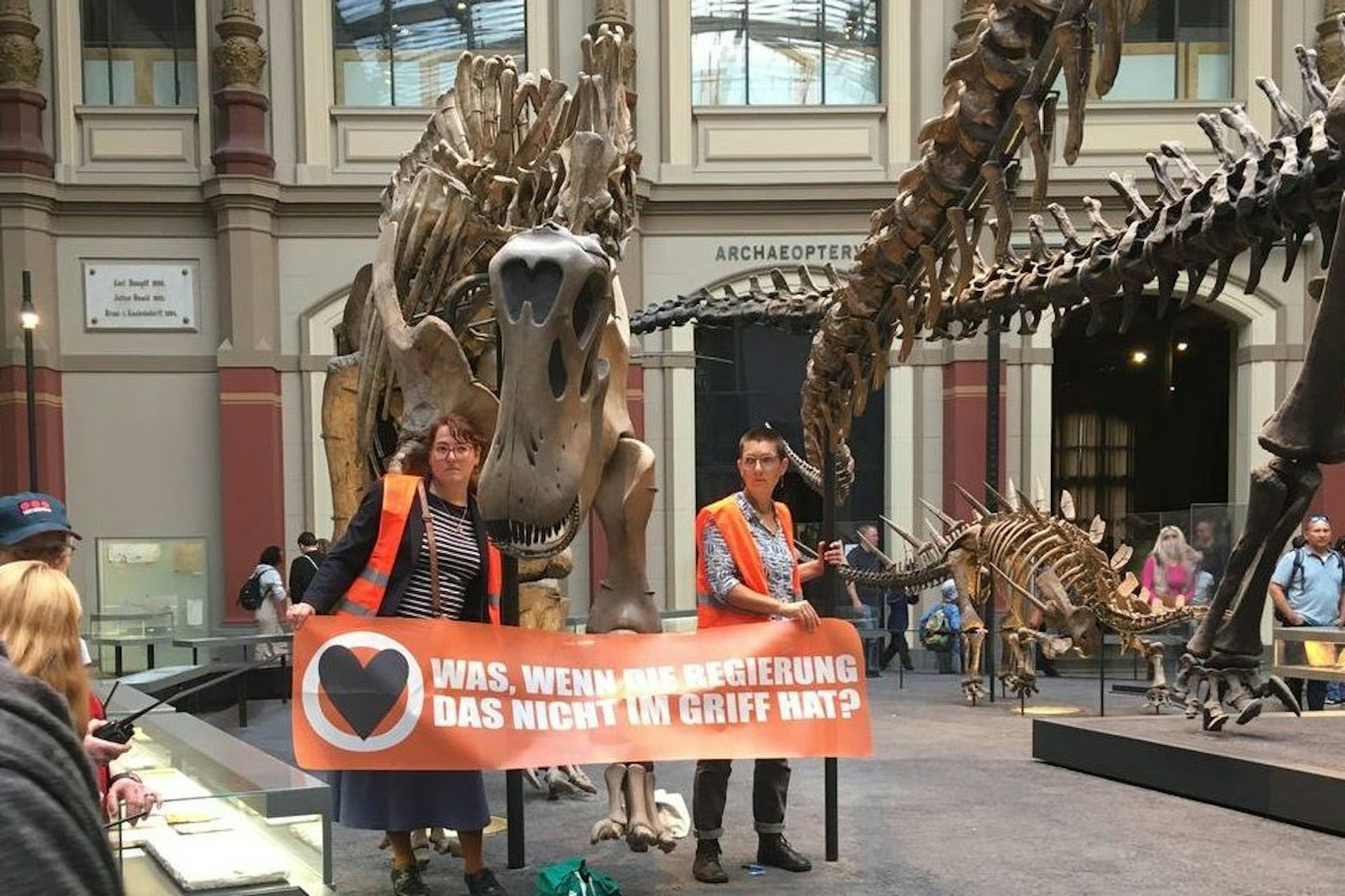 Zwei Frauen der „Letzten Generation“ haben sich an einem Dinosaurier-Skelett festgeklebt. 