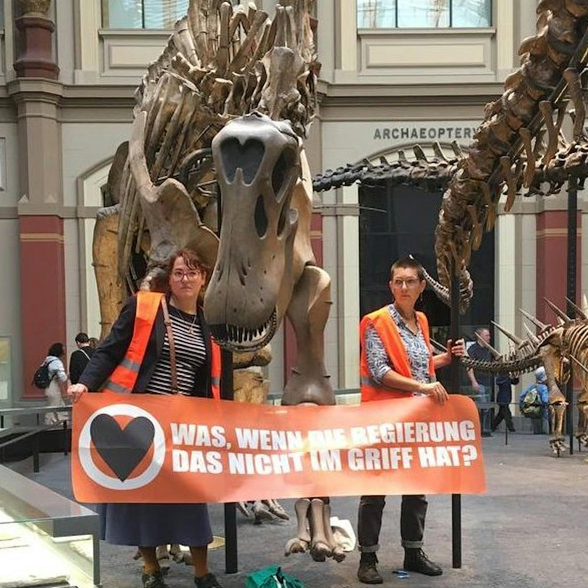 Berlin: Klima-Mütter kleben sich an Dinosaurier-Skelett fest