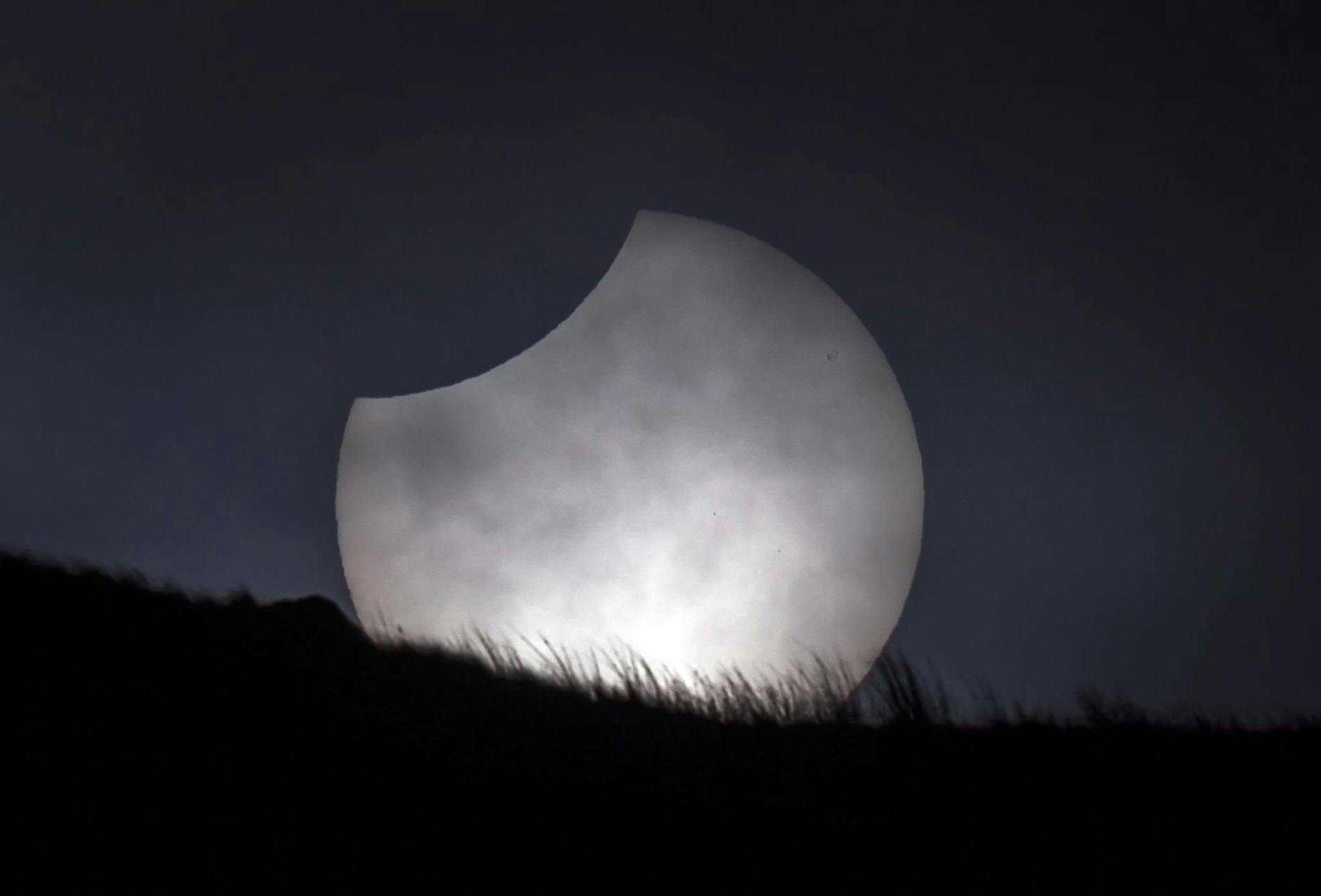 Die Sonne bricht während einer partiellen Sonnenfinsternis über Stoodley Pike in Großbritannien durch die Wolken.