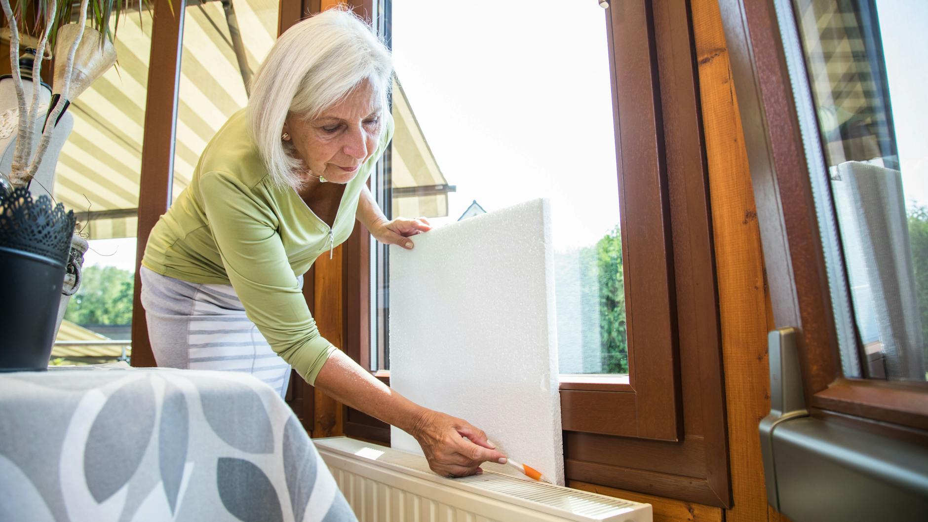 Die Wand hinter einem Heizkörper lässt sich mit Dämmstoffplatten isolieren – und so geht weniger Heizwärme verloren.